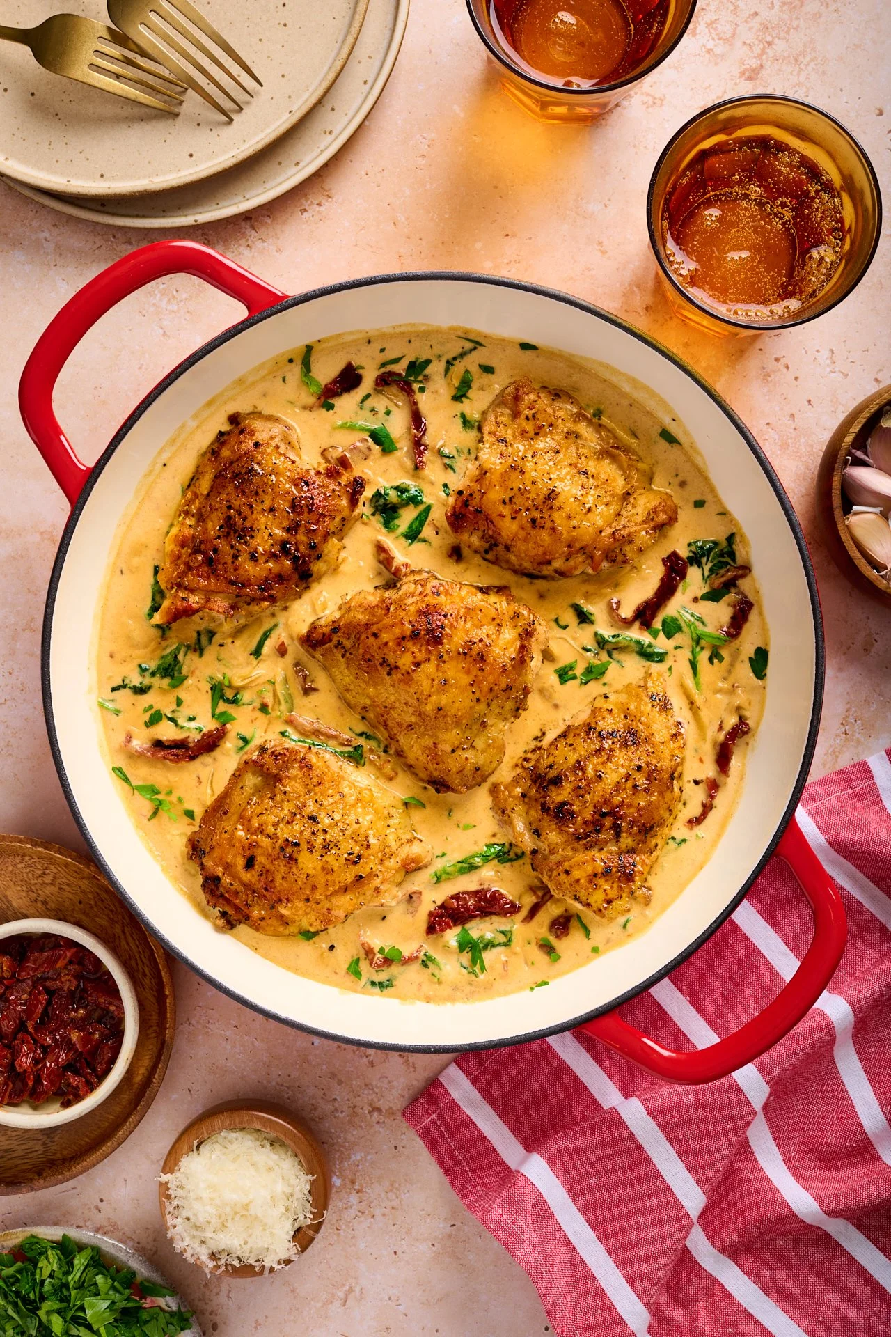 pot of tuscan chicken with sundried tomatoes surrounded with grated parmesan and fresh parsley