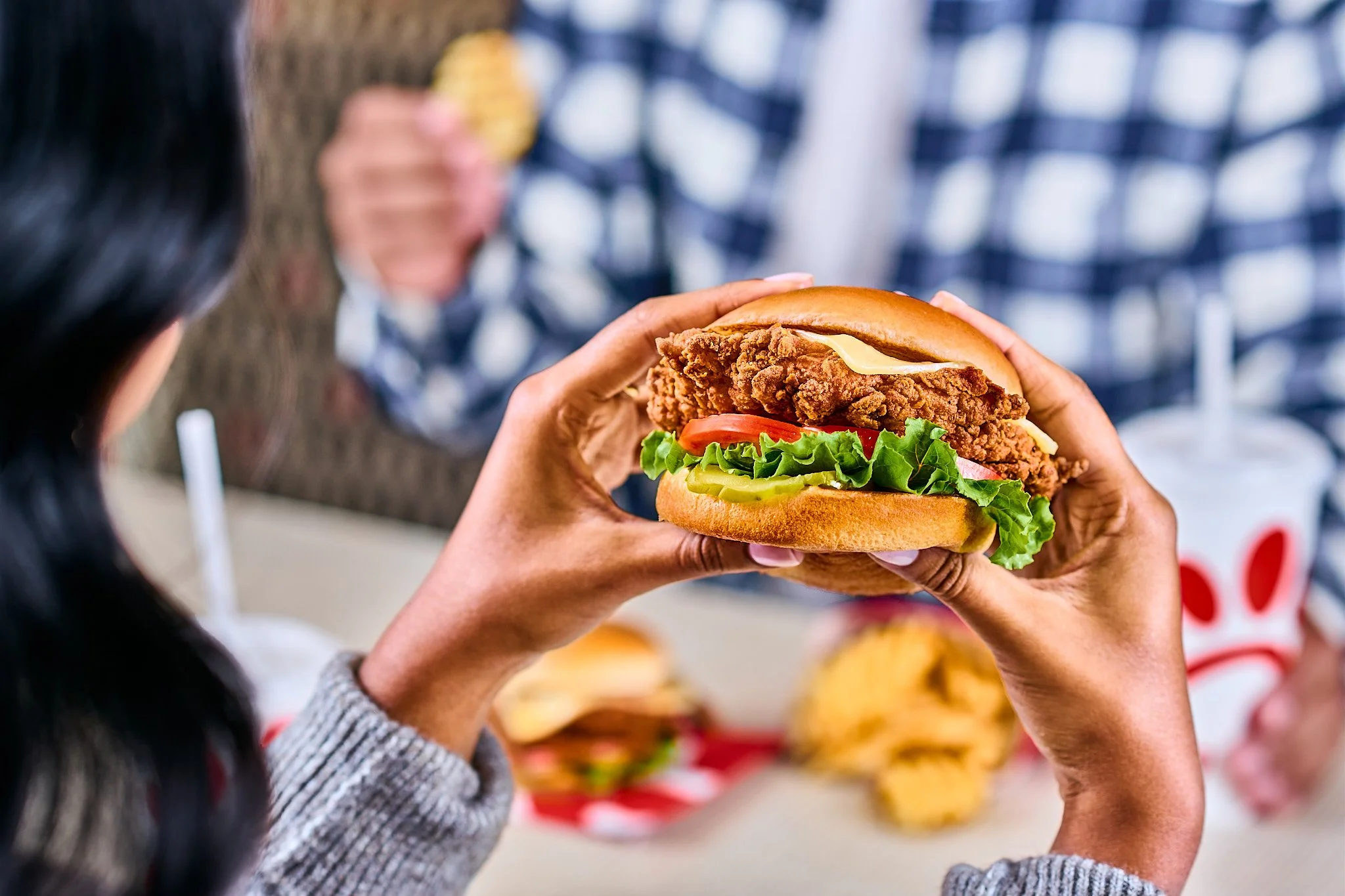 crispy chicken chick-fil-a sandwich taken on location with production studio lighting with model holding sandwich