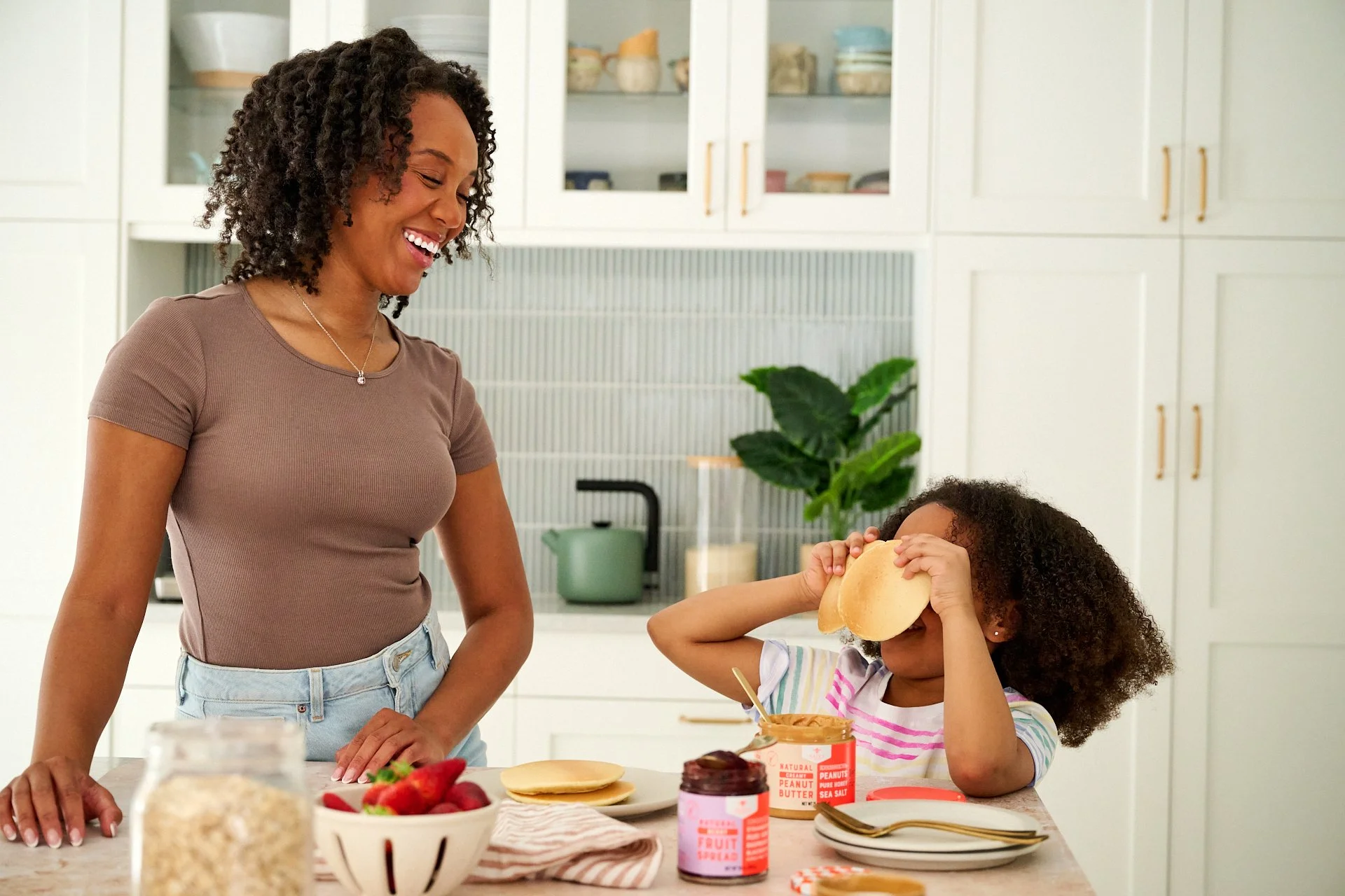 mom and daughter making a pancake breakfast spread in the kitchen