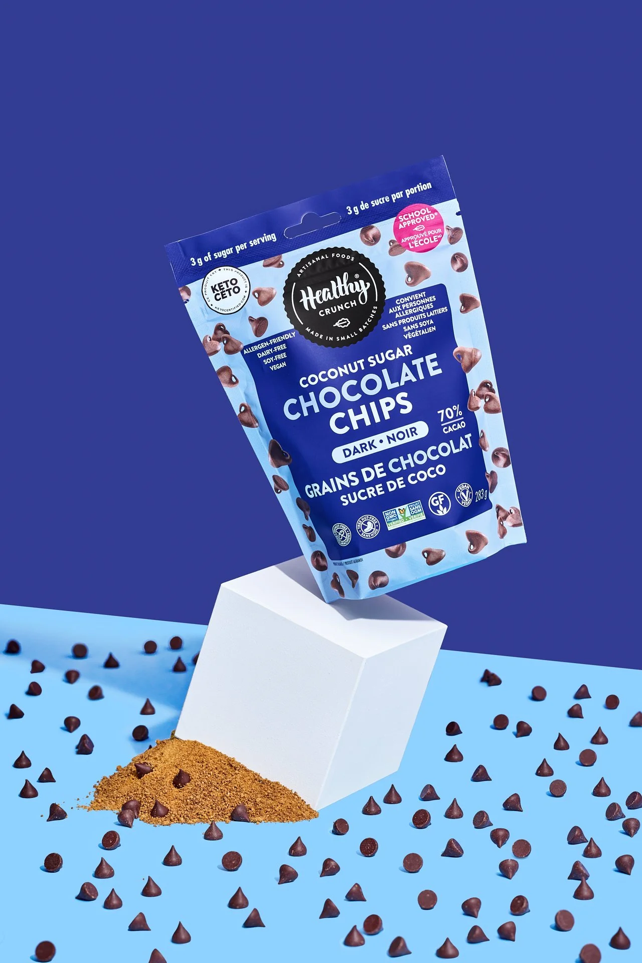 bold, colorful, vibrant creative food product photography of healthy crunch coconut sugar sweetened chocolate chips and packaging styled on a bold blue set.
