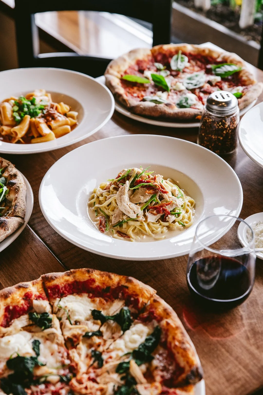 plates of pasta and pizza on a table in an italian restaurant