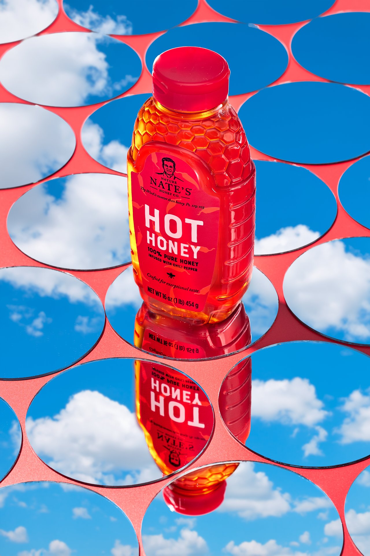 bottle of honey against round mirrors, an abstract concept for commercial photography