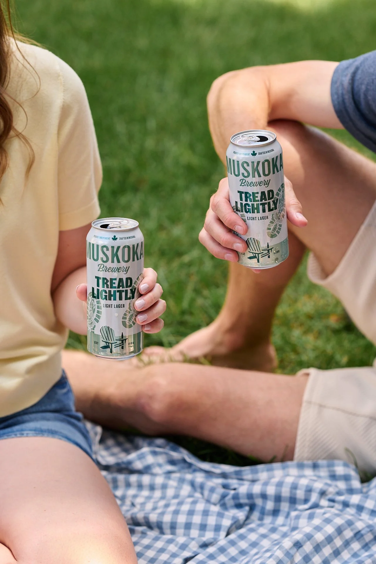 Lifestyle beverage photography featuring muskoka brewery tread lightly canned beer enjoyed outdoors on a sunny day.