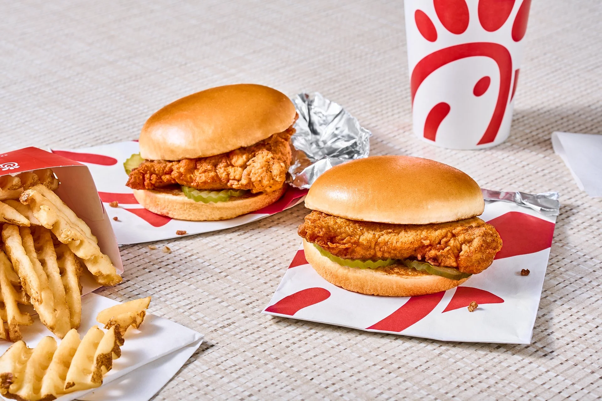 Commercial food photography of chick-fil-a's crispy chicken sandwiches styled with branded packaging and a clean tabletop setting.