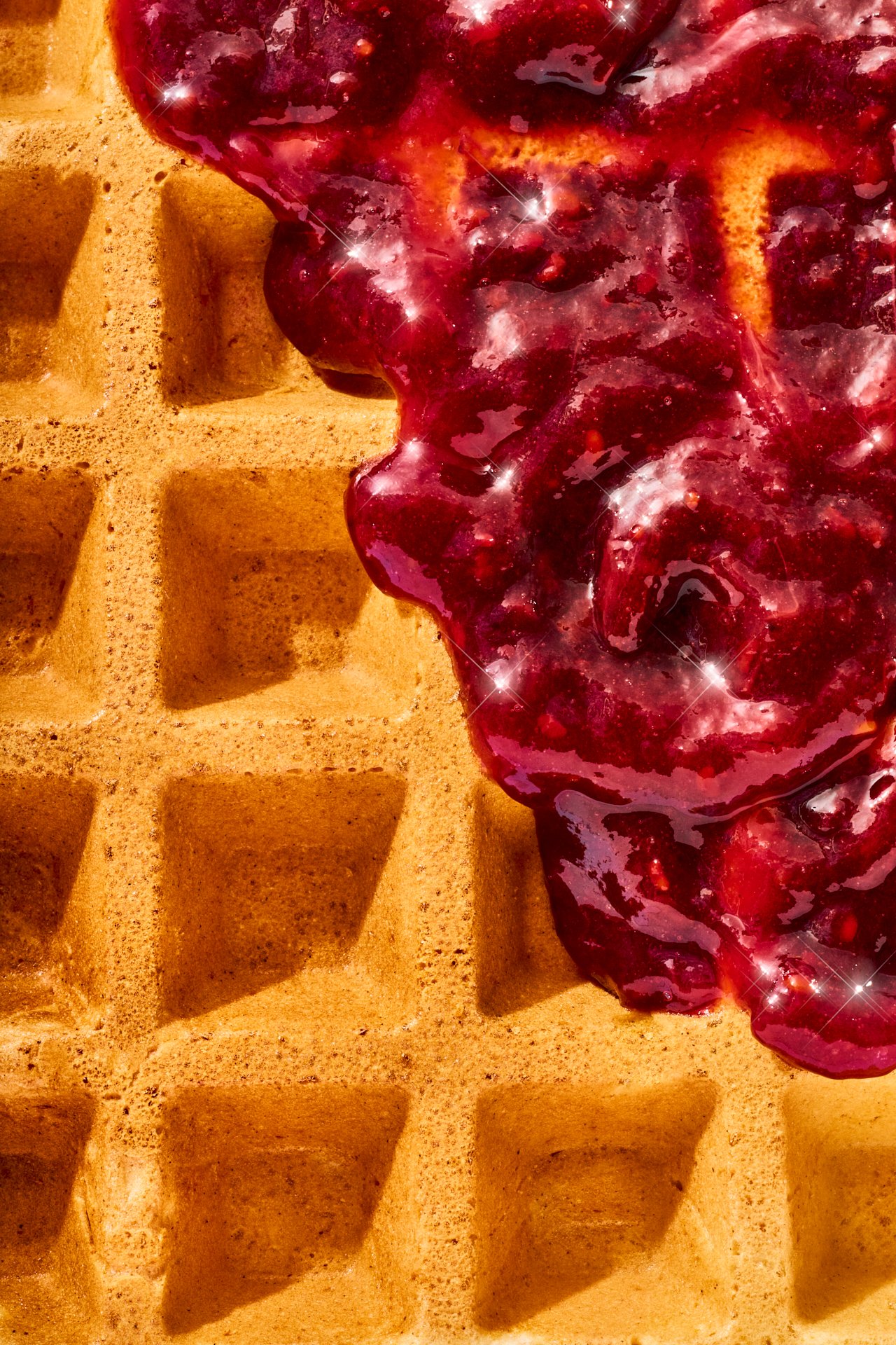 a studio shot of a waffle and fruit spread covering the holes