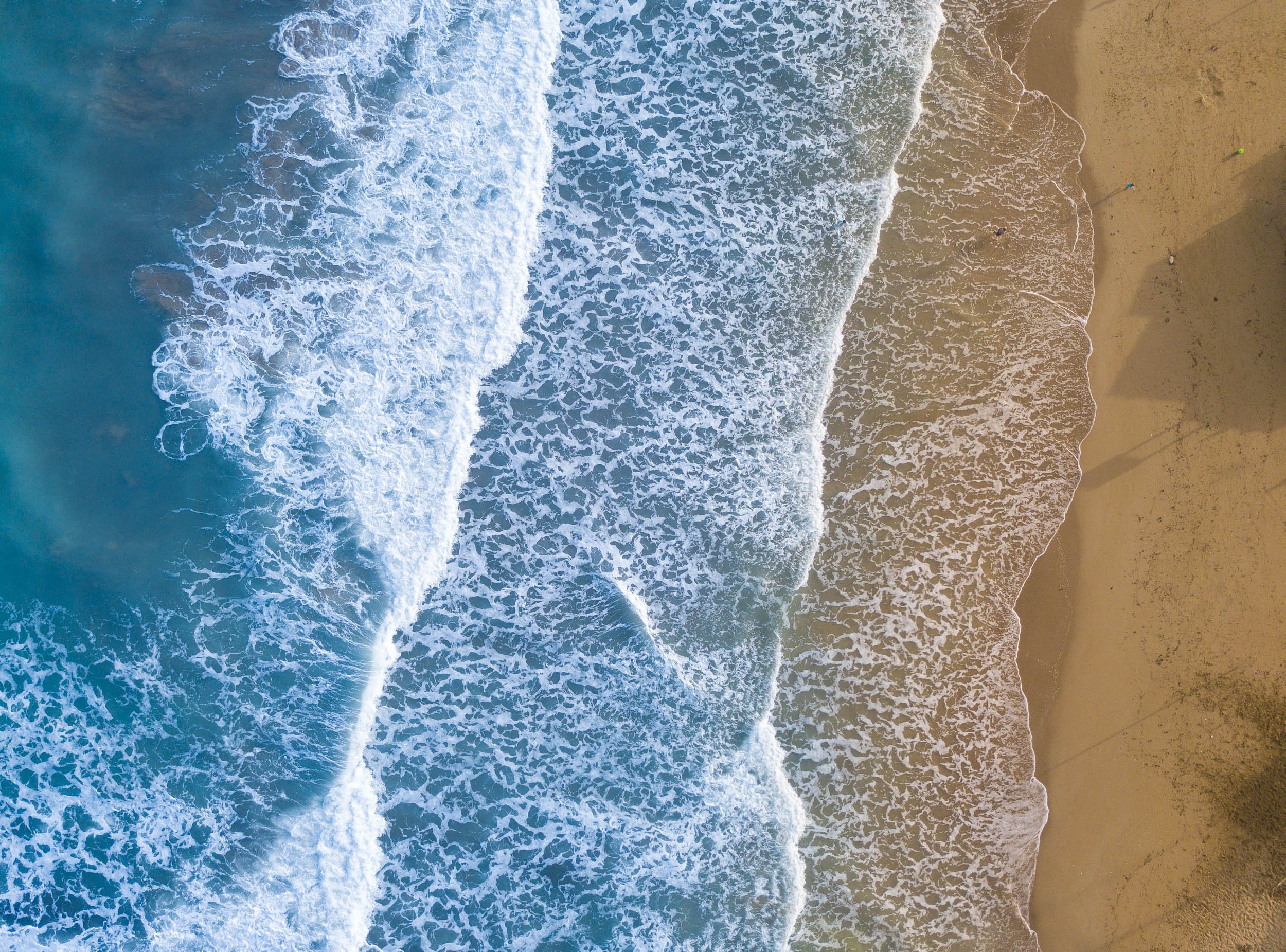 Aerial view of waves breaking on paradise beach
