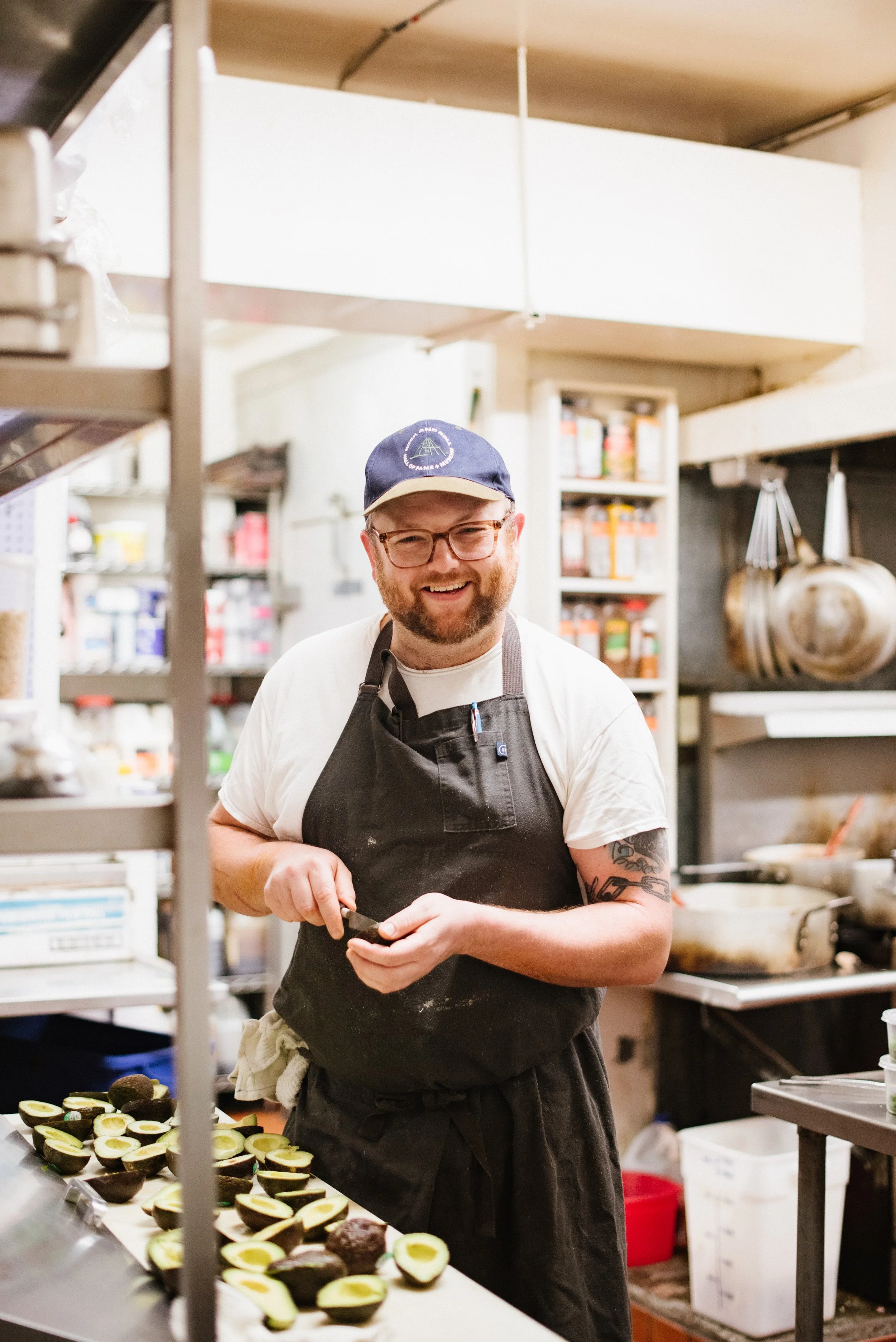 Smiling man preparing avocados in a commercial kitchen