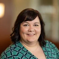 Women with short brown hair and green business shirt