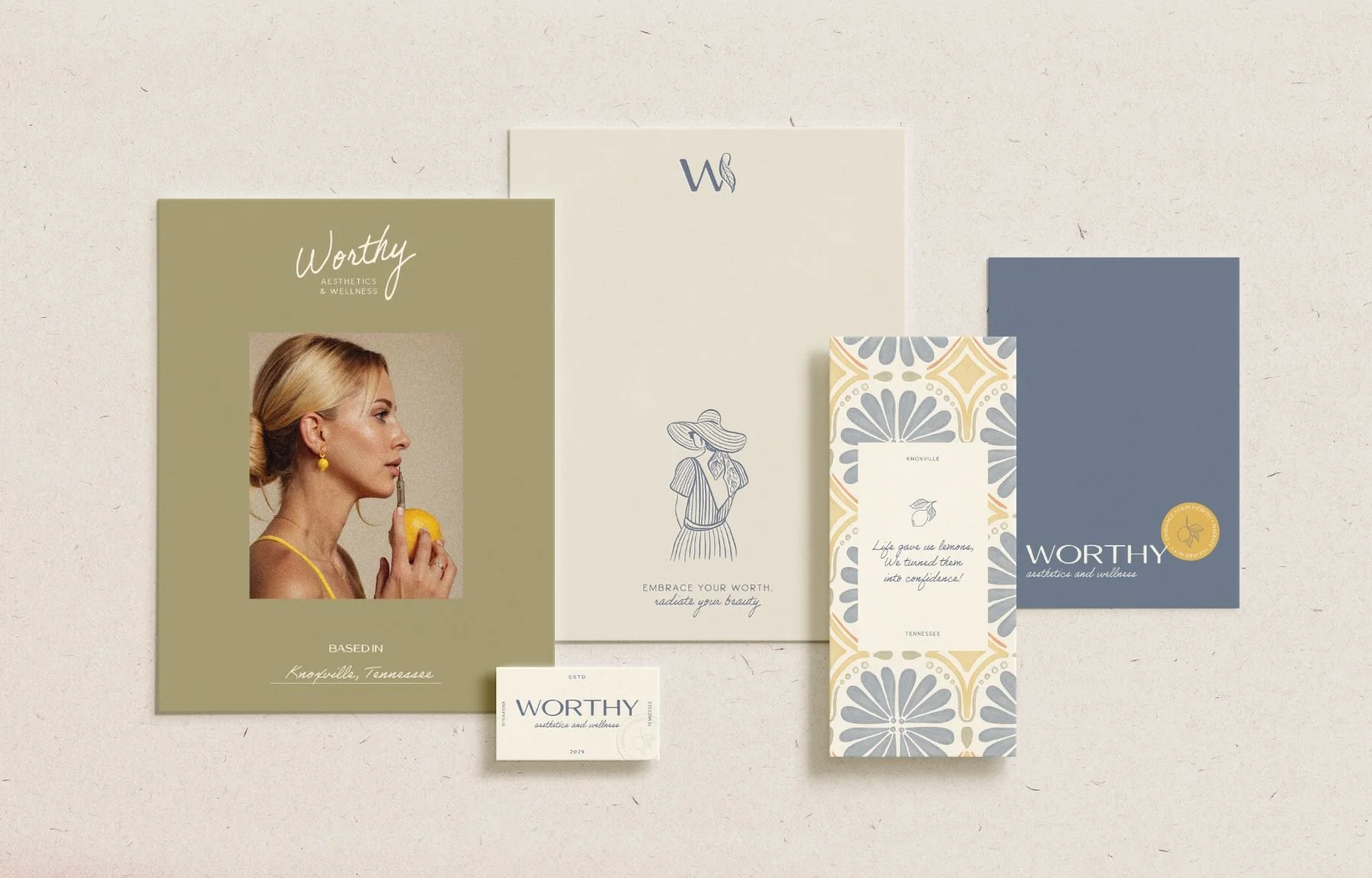 Collection of branding materials, including a photo of a woman holding a lemon, with text referencing Worthy aesthetic and wellness, and various patterned and plain cards with understated designs.