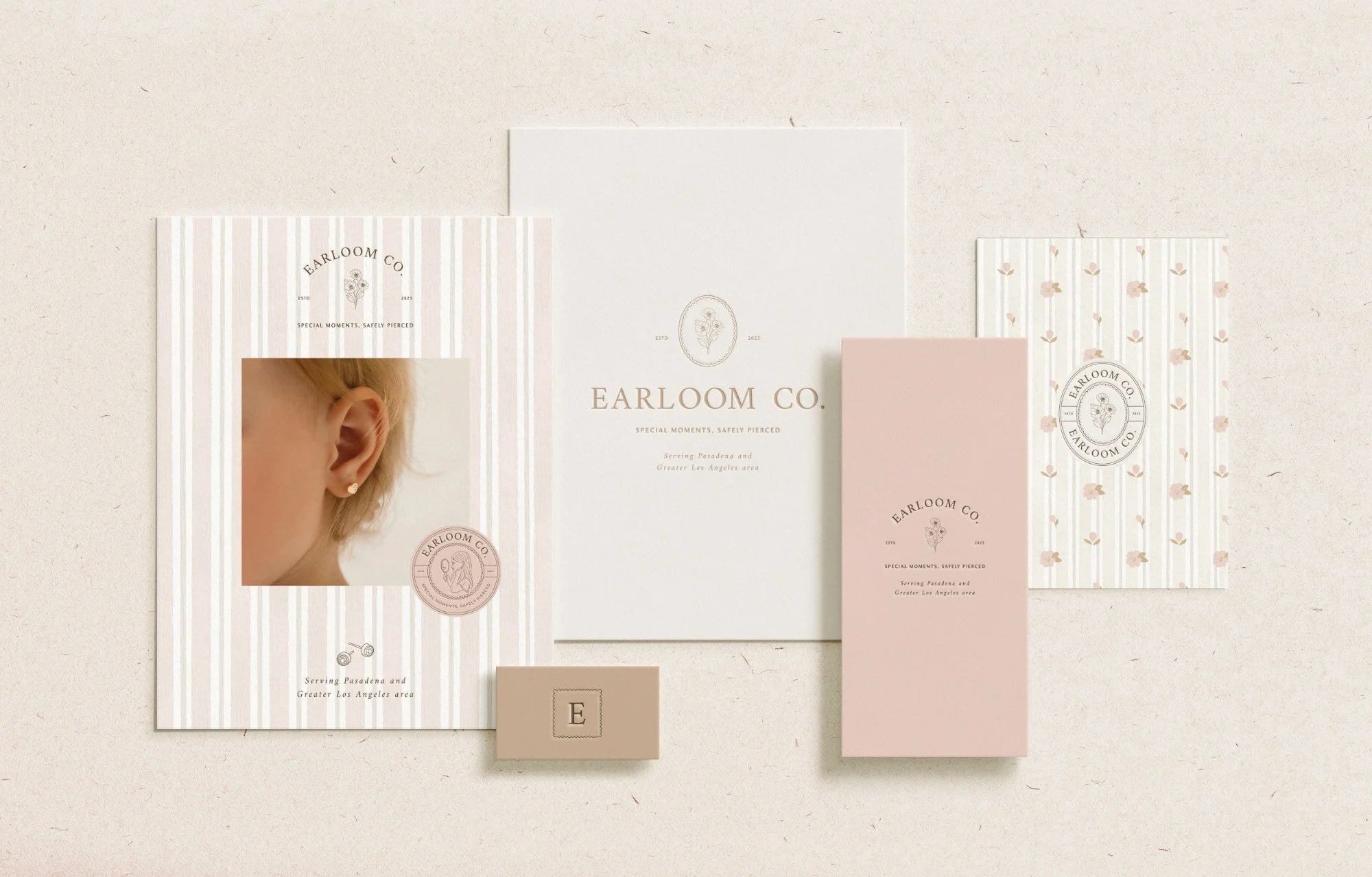 Scalloped lace-inspired oval frame with tiny stud earring details, symbolising heirlooms and treasured first milestones. Cards mockup of earring brand company branding design soft pinks and vintage painted wallpaper
