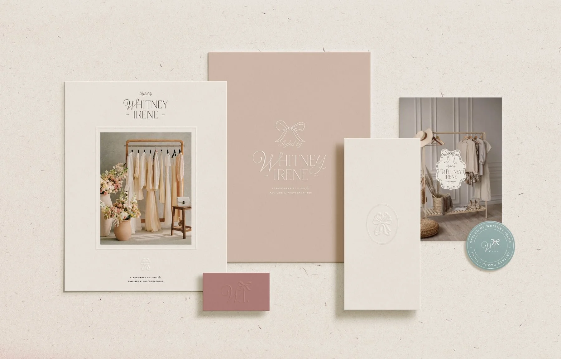 Set of branding materials including a large photo of a wardrobe with dresses, a pink and white branding booklet, a white envelope with embossed logo, a business card, and a smaller photo of a display with clothing, all styled by Whitney Irene.