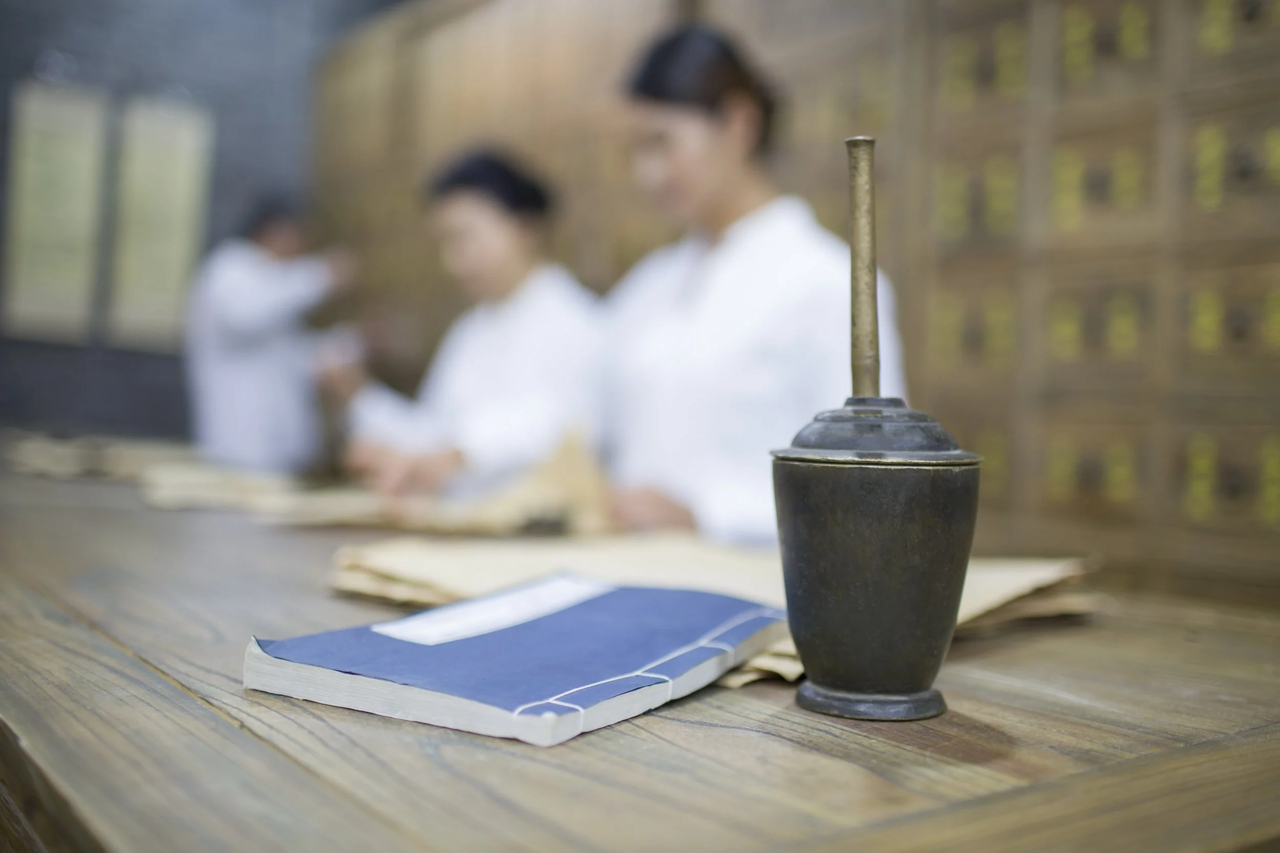 TCM therapy in Singapore showing traditional Chinese medicine tools and herbal records in a professional clinic setting