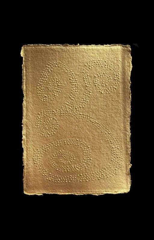 Gold-colored, textured surface with the words 'LOVE YOU' spelled out in small dots.