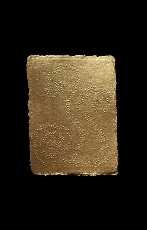 A textured, beige-colored surface with embossed swirly patterns on a black background.