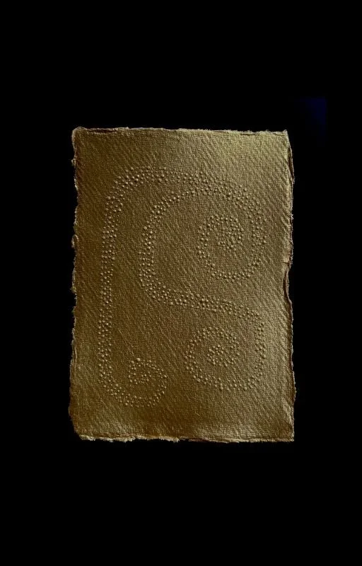A golden bar with a textured surface displaying a pattern of small dots in swirling shapes, set against a black background.