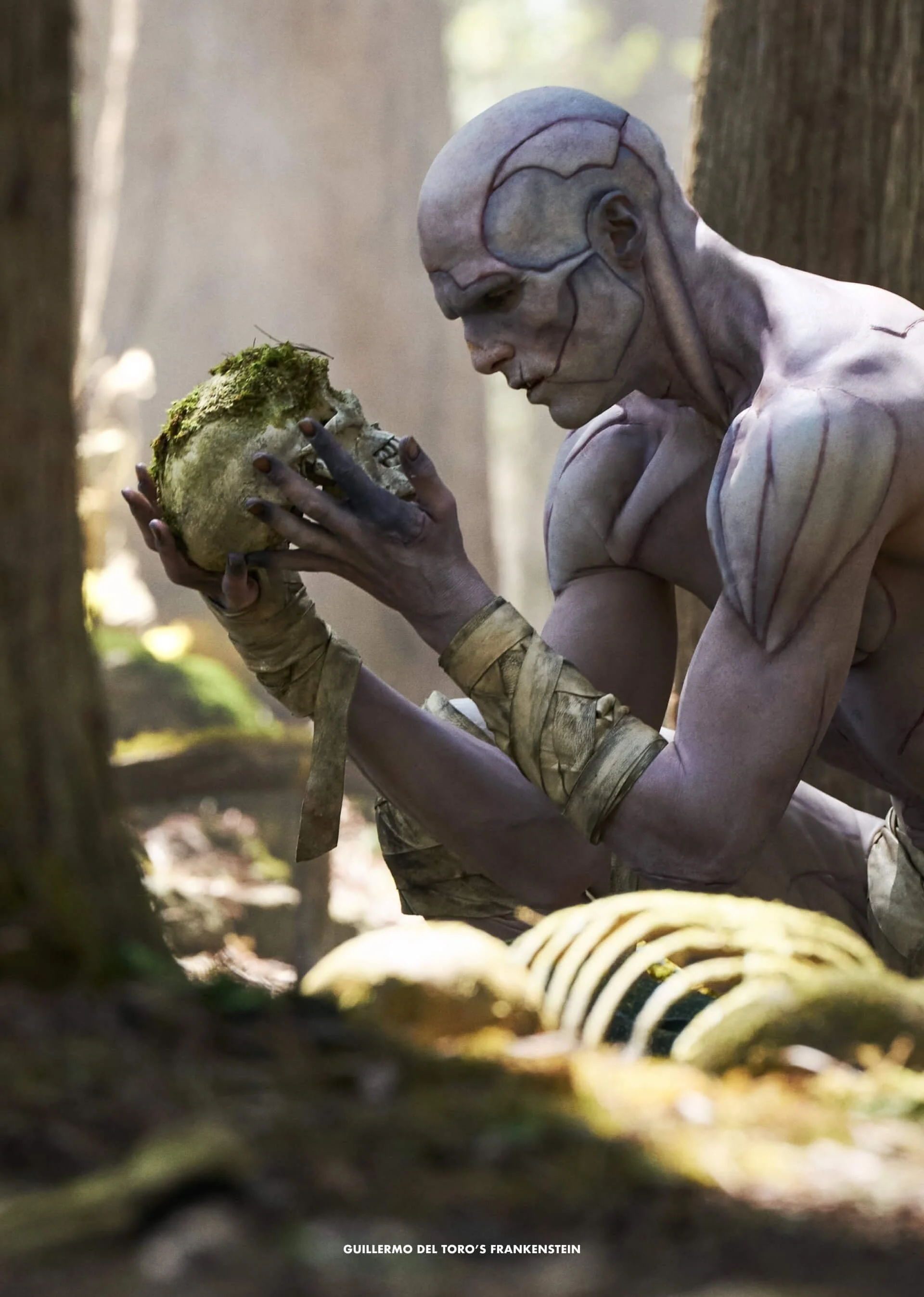 A humanoid character with gray skin, black markings, and an exposed brain, kneeling amidst trees and holding a moss-covered skull in a forest setting.