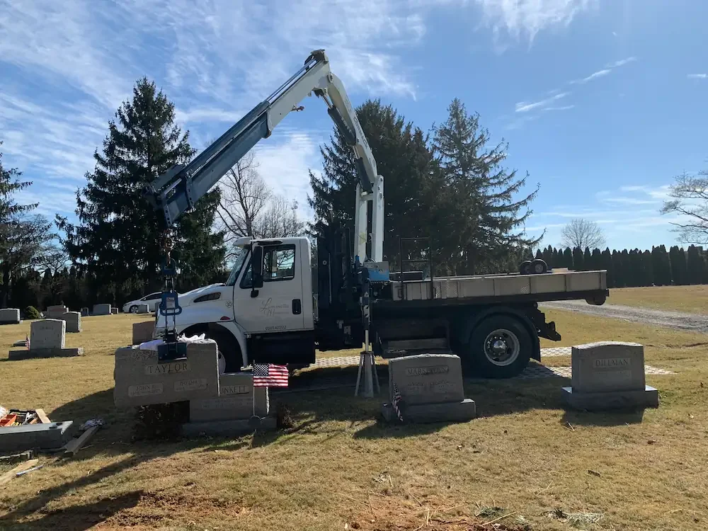 Truck crane lifting a headstone in a cemetery