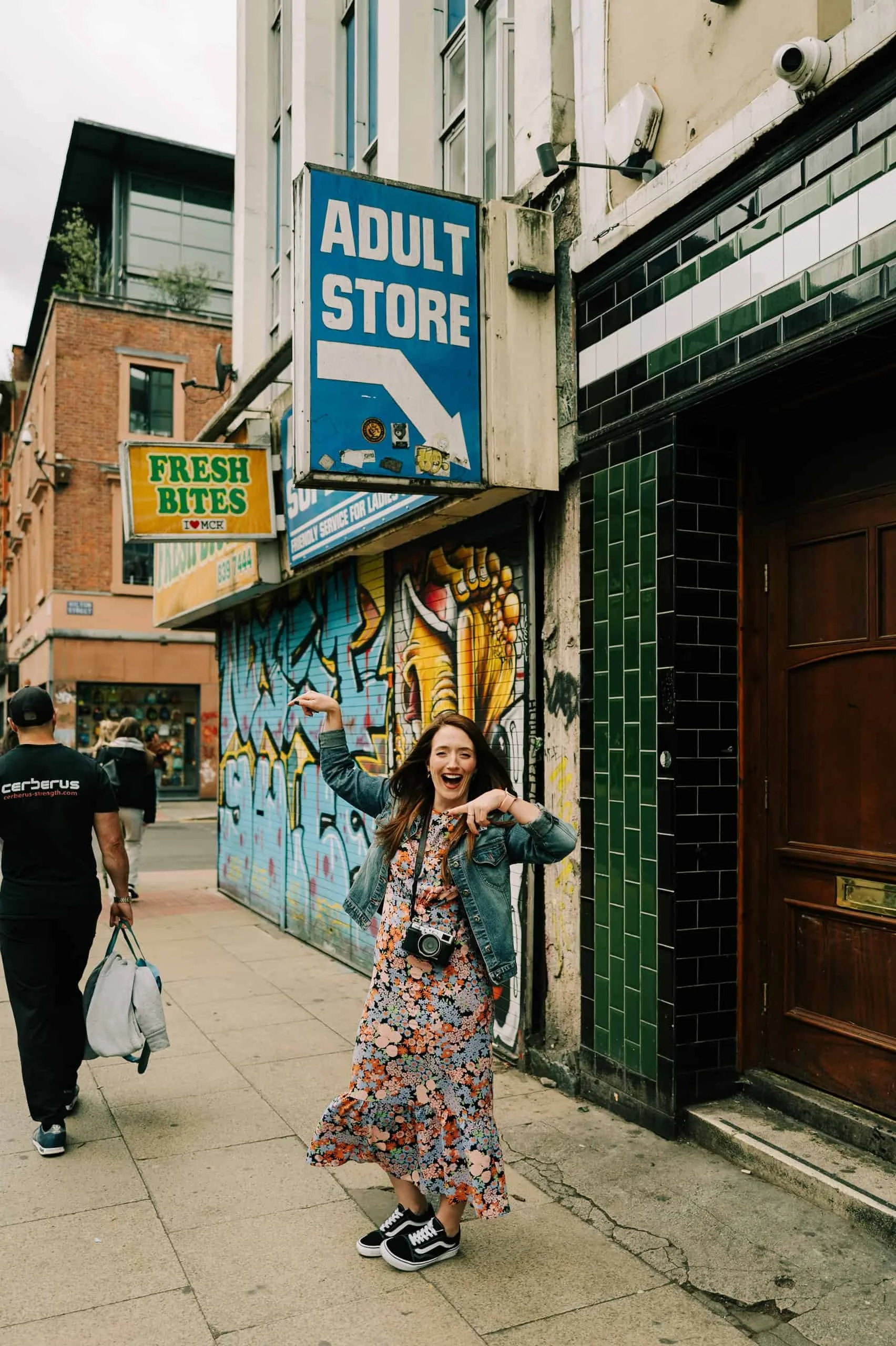 clare robinson photography laughing her head off whilst stood under an adult store sign and pointing goofily at a passerby