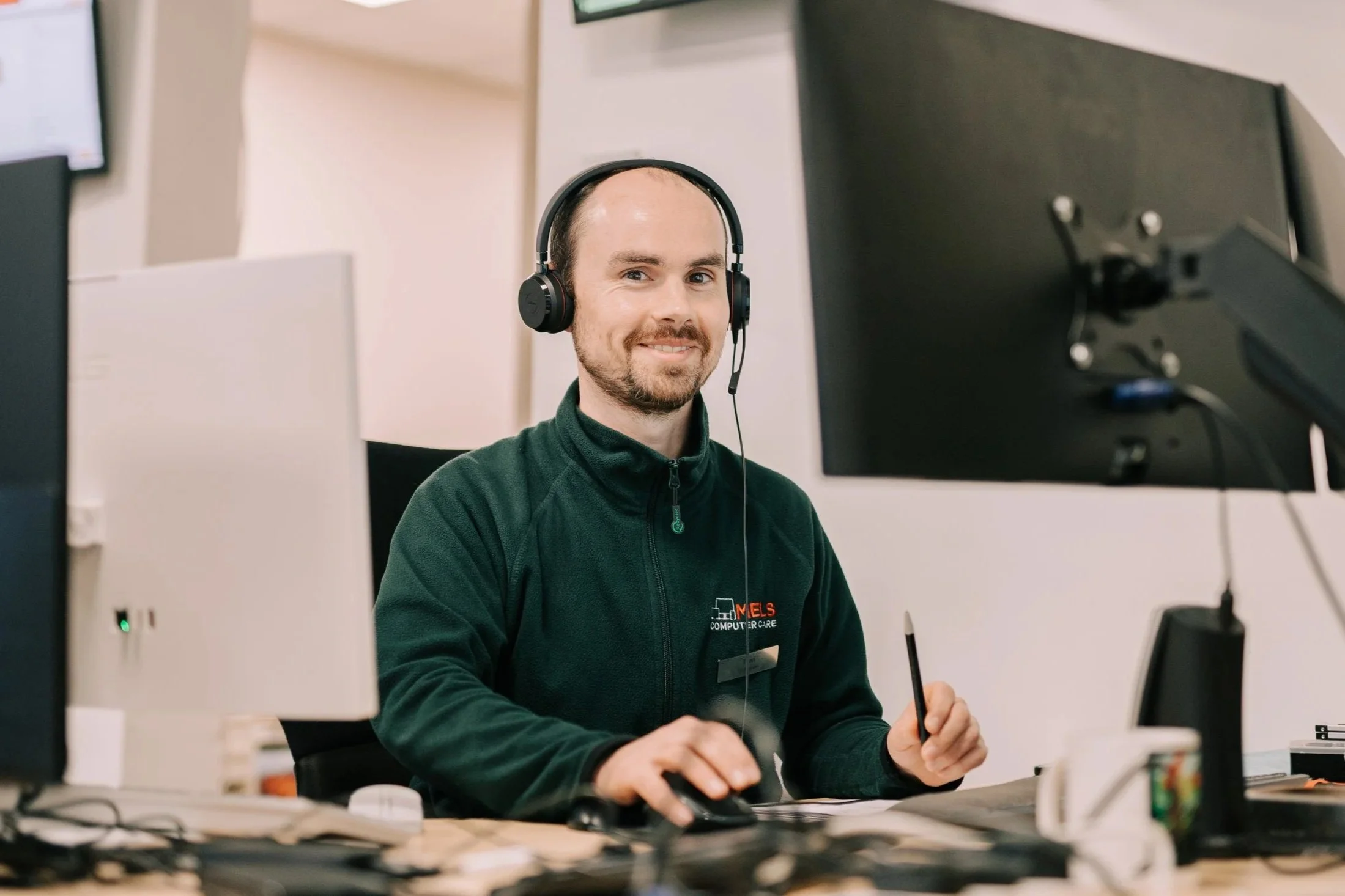mels computer care staff on the phone, looking at the camera smiling