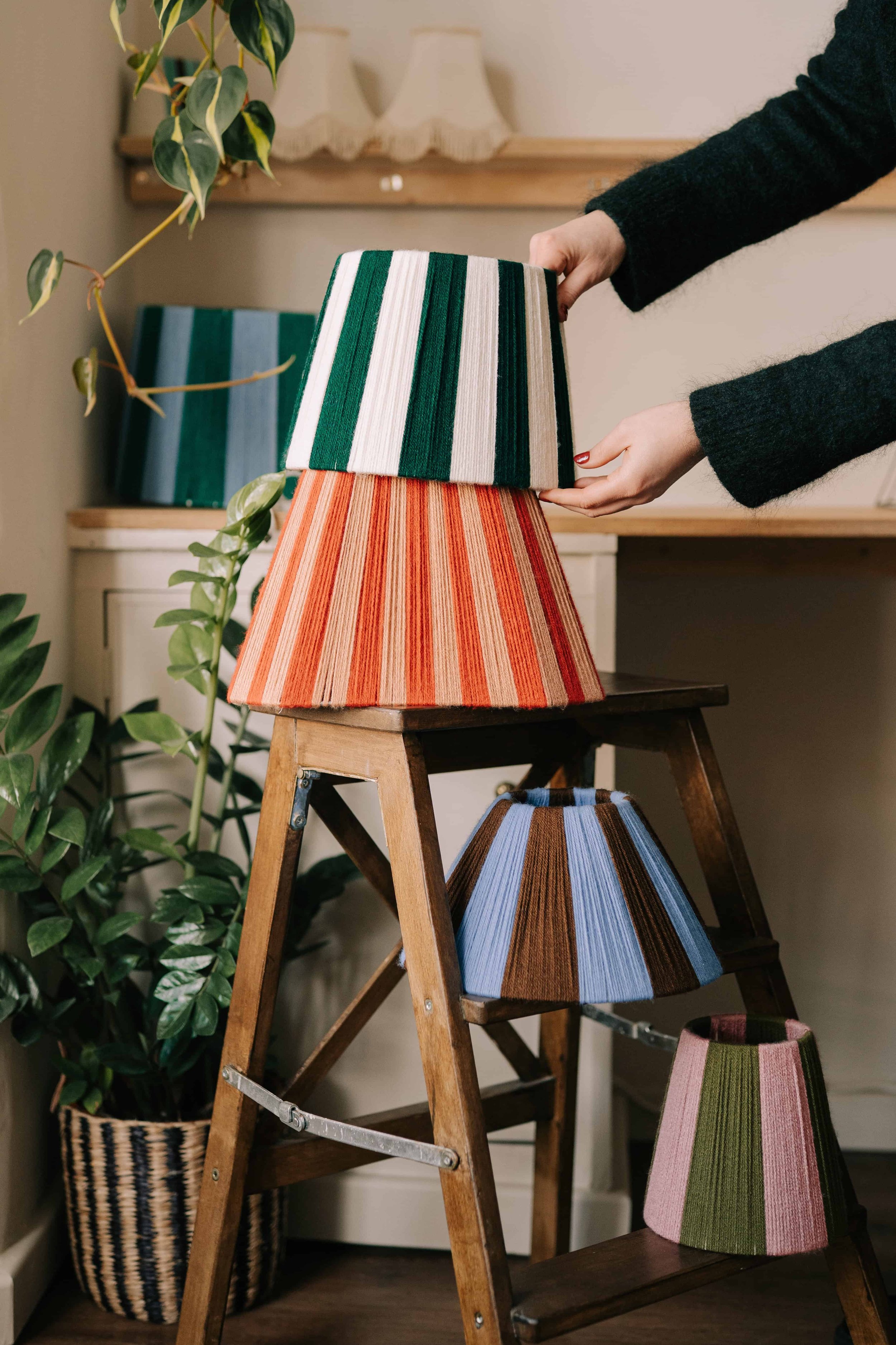 hand woven lampshades being stacked on small vintage step ladders