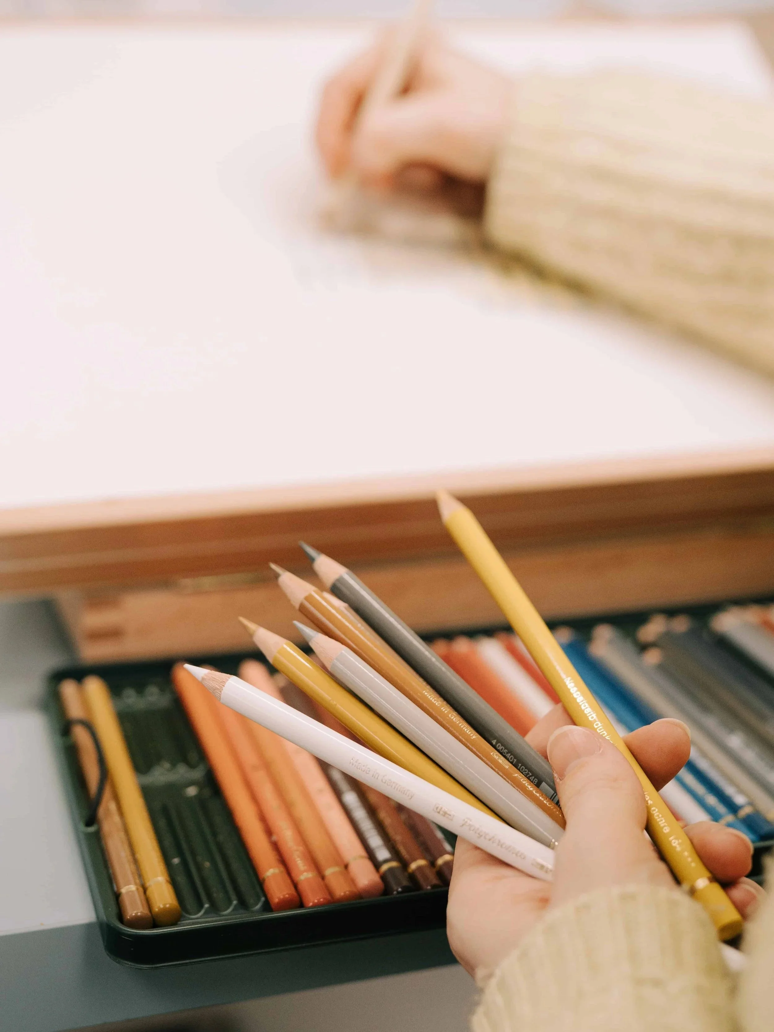 Lydia Draws with a handful of coloured pencils