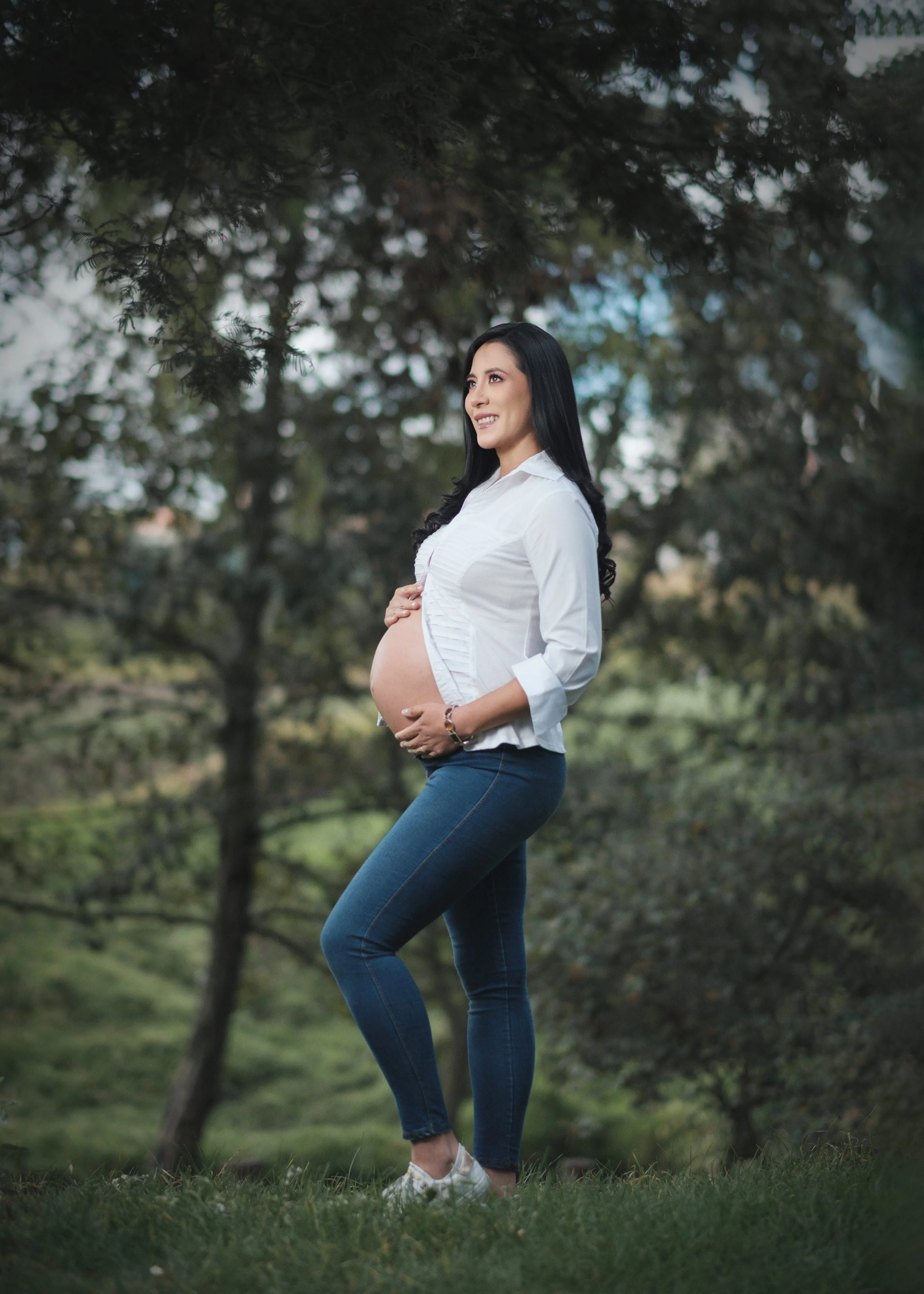 Mujer embarazada con jeans y camisa blanca en una sesión de embarazo en exteriores, Riobamba