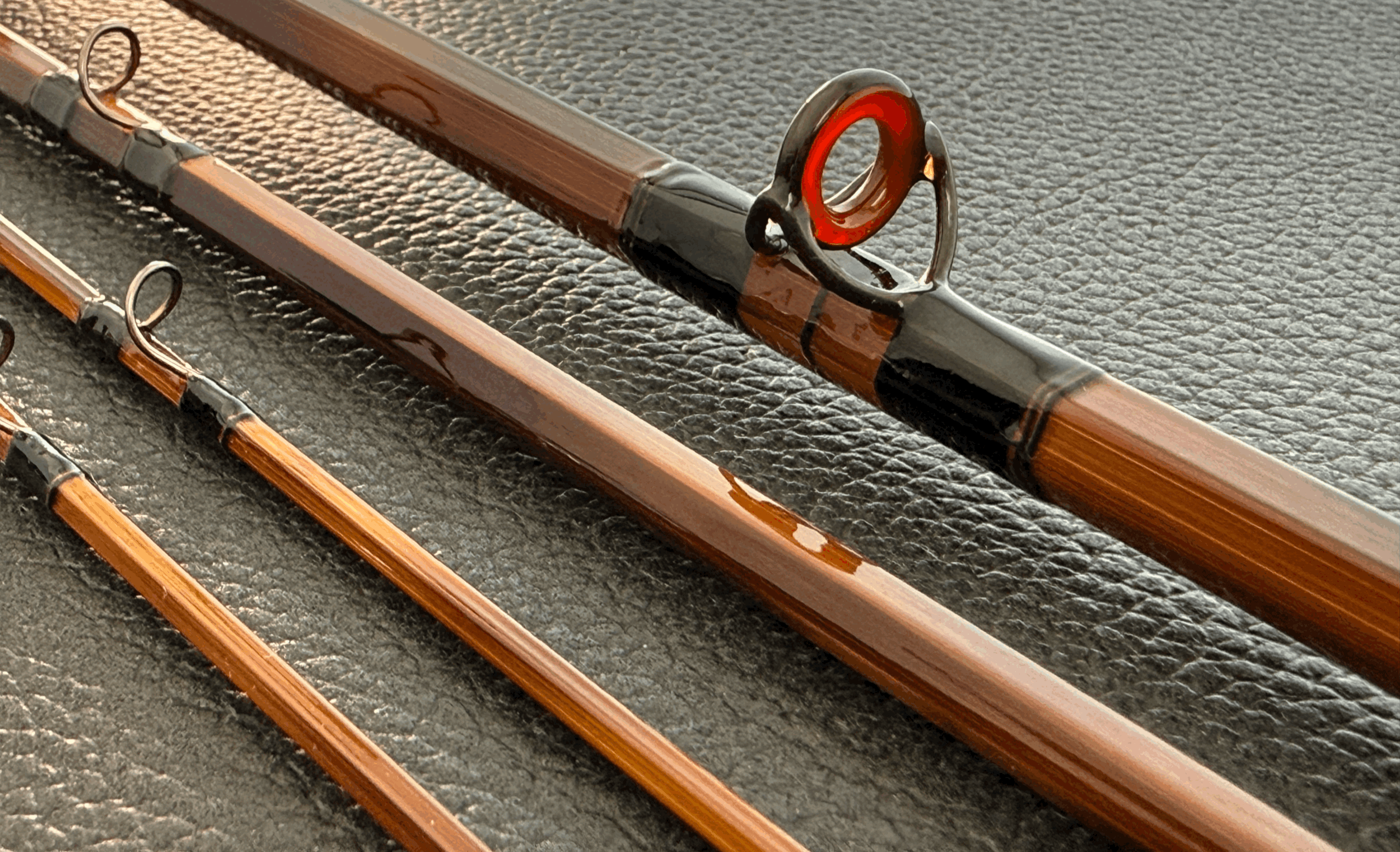 Four rod sections lying diagonally. One features red agate stripping guide.