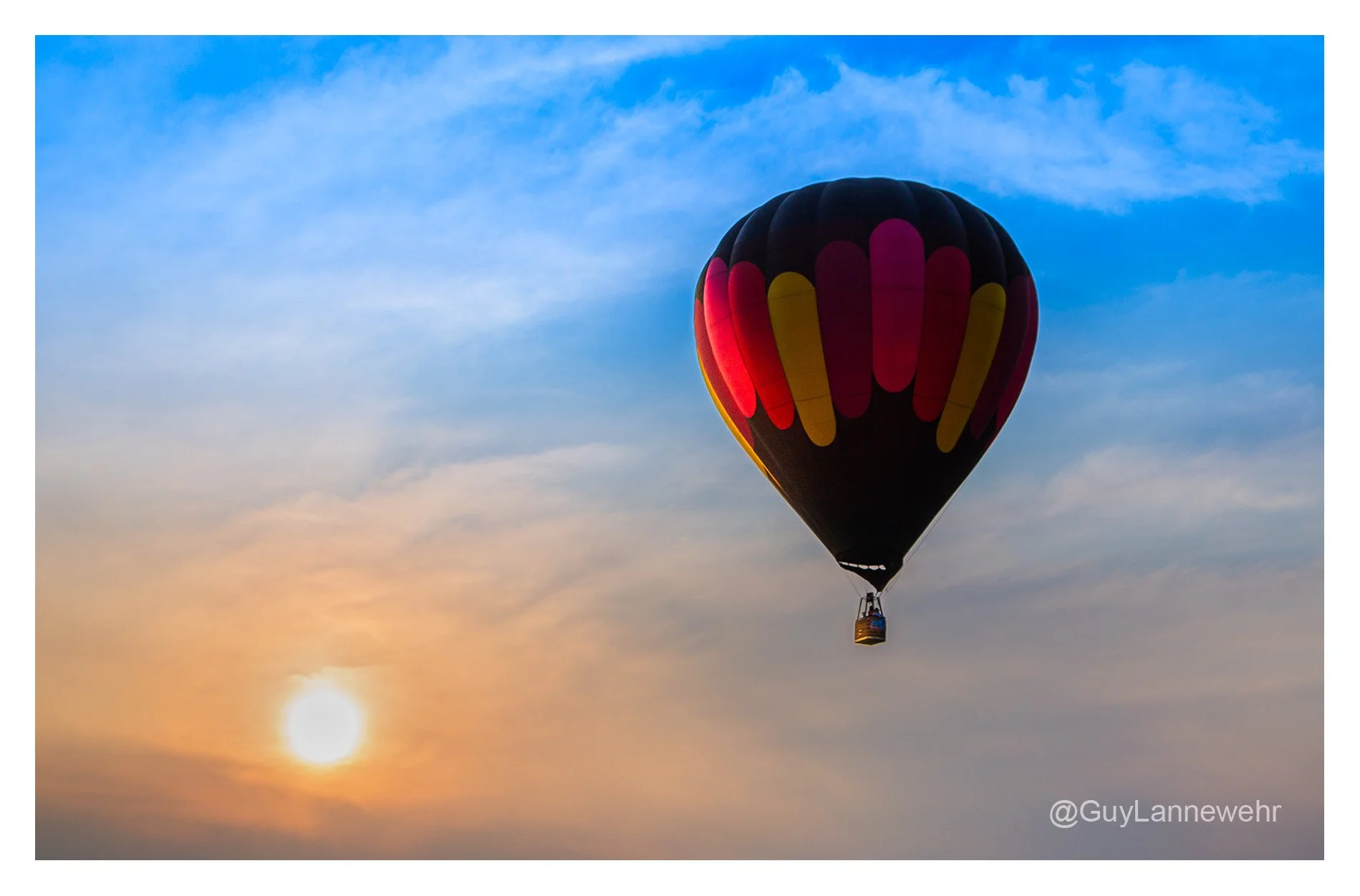 "Bathed in golden light, the balloon floats where daylight surrenders to dreams."

Another image of the hot air balloon event from a few years ago. Perfect weather against a perfect sky during the early evening sunset.

#HotAirBalloon
#Ball