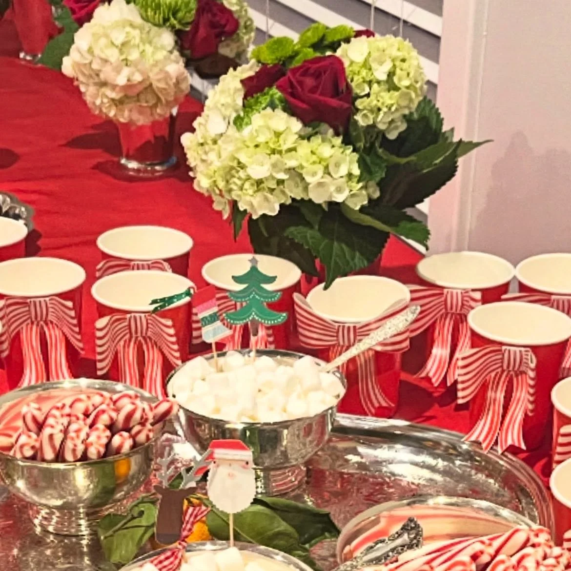 A cozy hot cocoa bar with darling bow cups by @merimeriparty and peppermint sticks with plenty of mini marshmallows