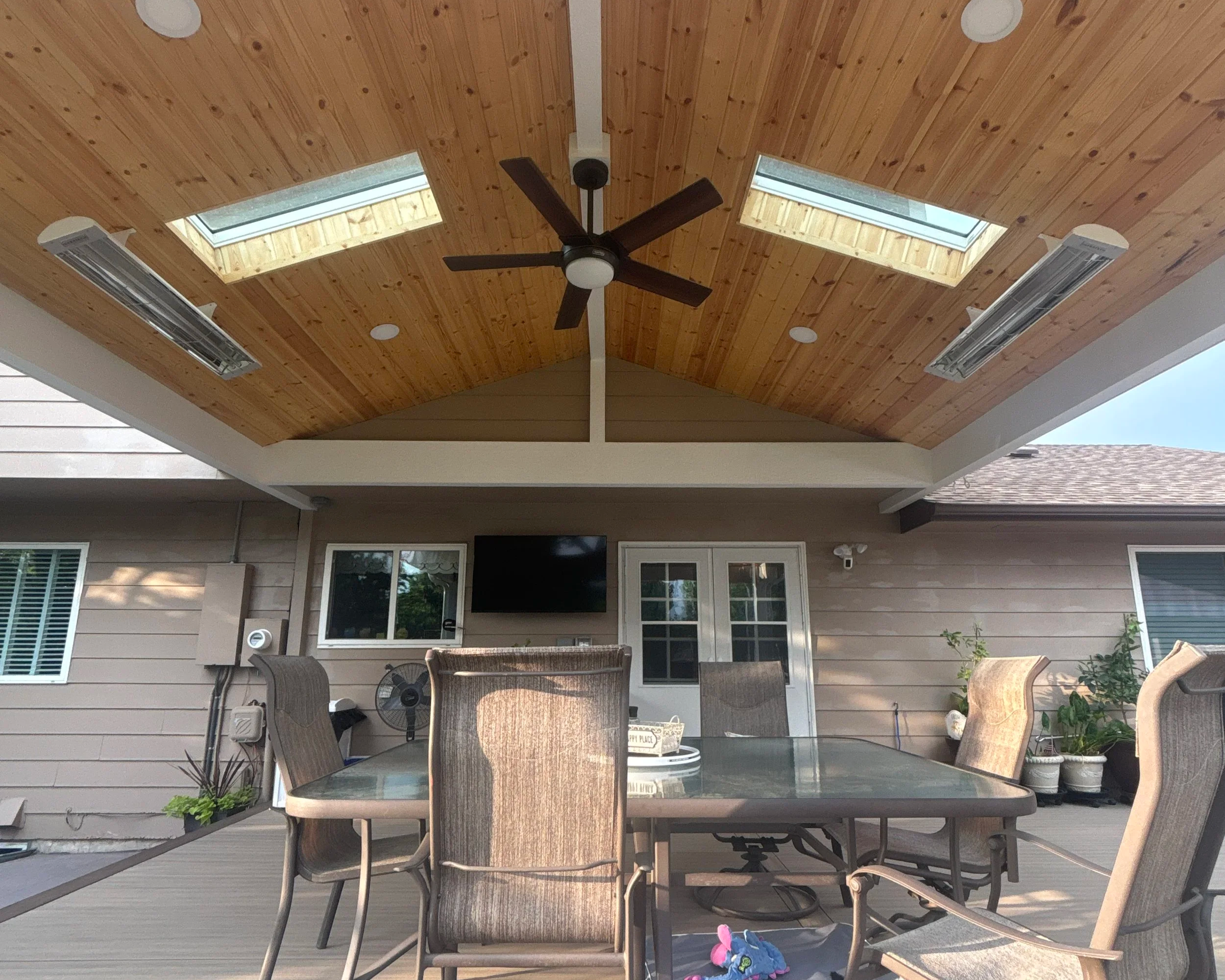 Skylights and a ceiling fan in the wood ceiling of a covered patio in Colorado