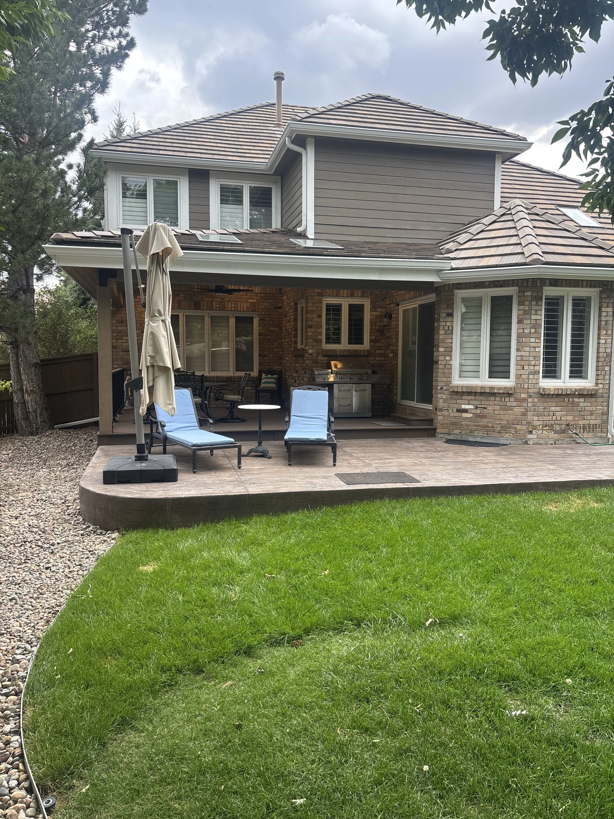 Covered deck beside a colored stamped concrete patio at a Highlands Ranch, Colorado home