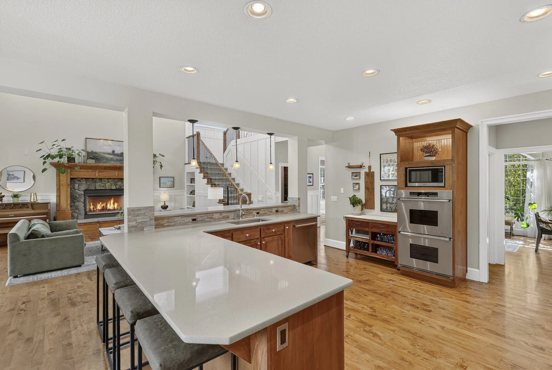 Open spacious kitchen overlooking a living room area with a fireplace