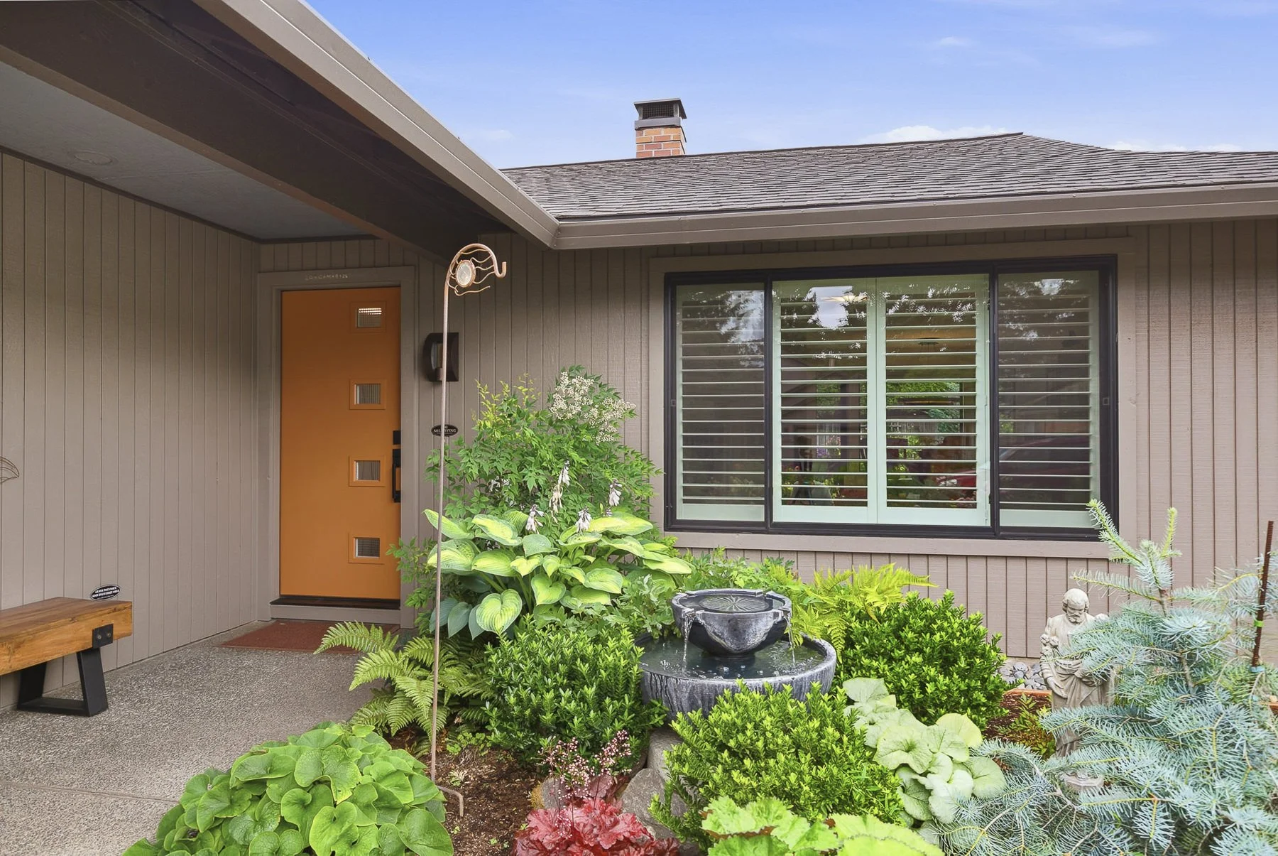 Exterior view of a home for sale in Vancouver, WA with a beuatifully landscaped yard with a water feature