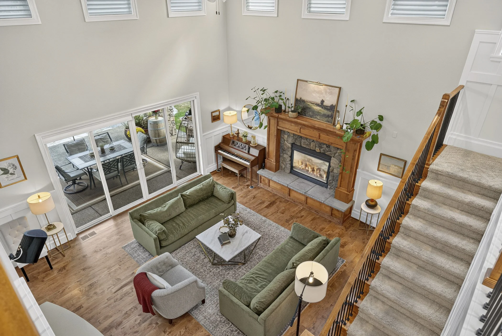 Bird's eye view of an open living room space with a fireplace and sliding glass doors