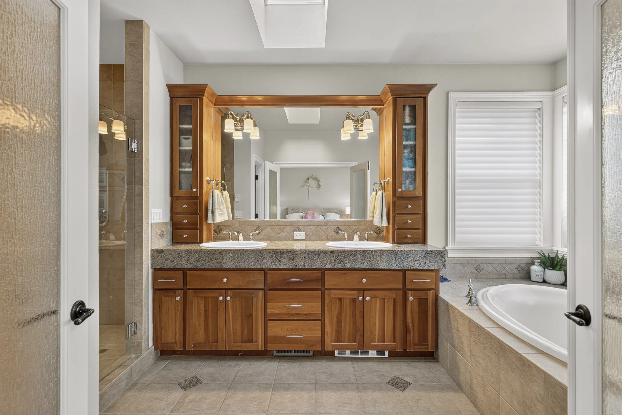 View peering through french doors of an elegant primary bathroom in Vancouver, WA