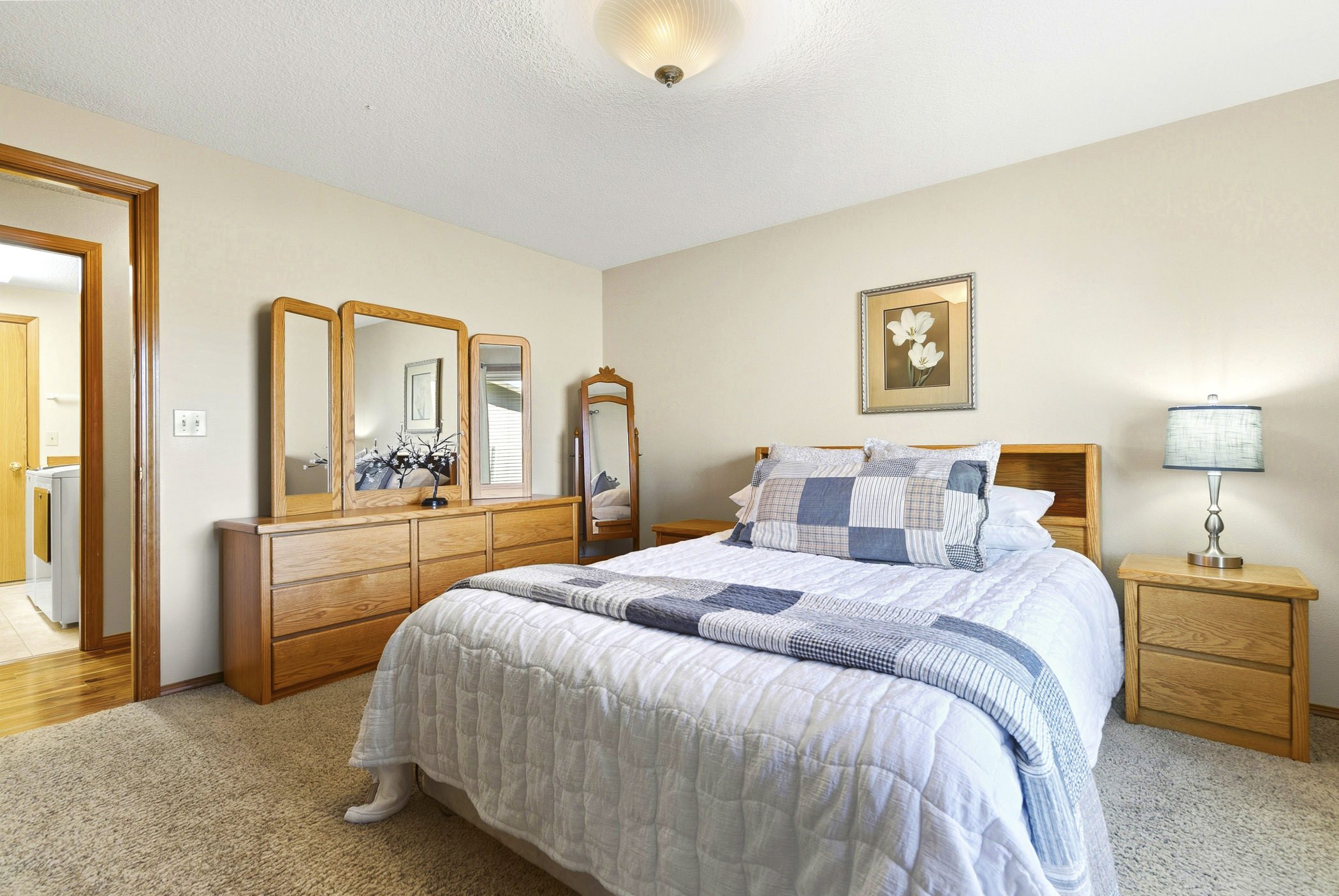 Primary bedroom with adjacent laundry room in Columbia City, OR
