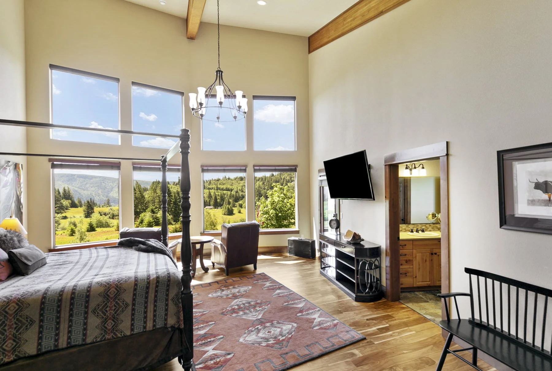 Primary bedroom in a contemporary lodge-style home in Washougal, WA that has large windows overlooking the Columbia River Gorge area.