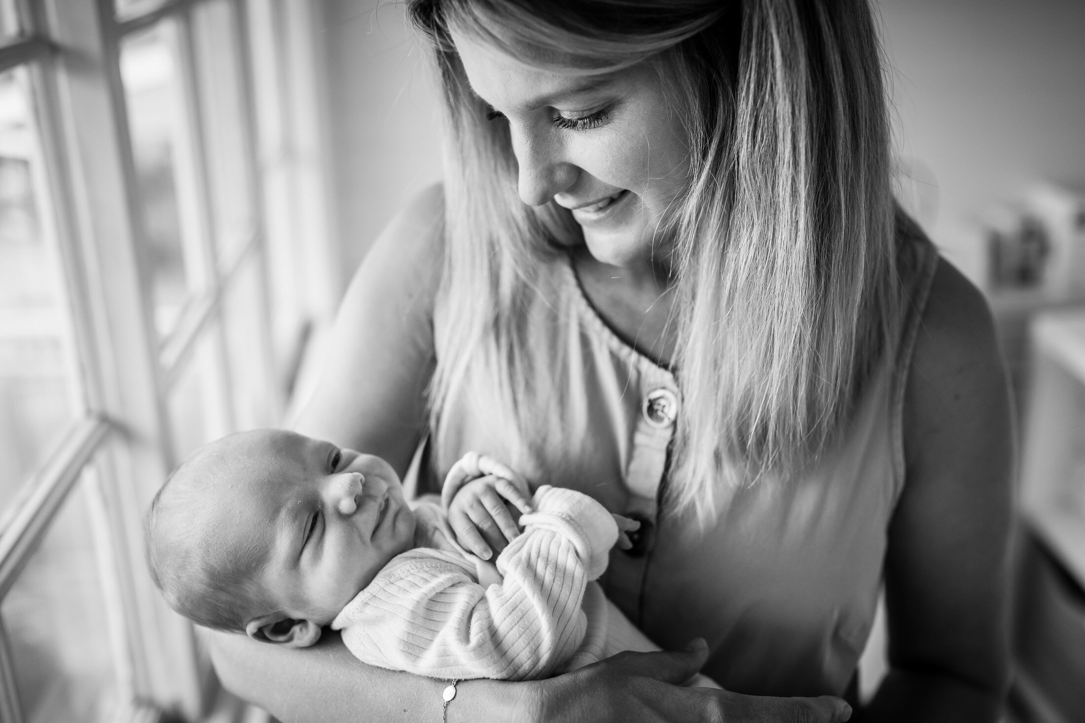 monochrome image of baby in mothers arms portland newborn photographer.jpg