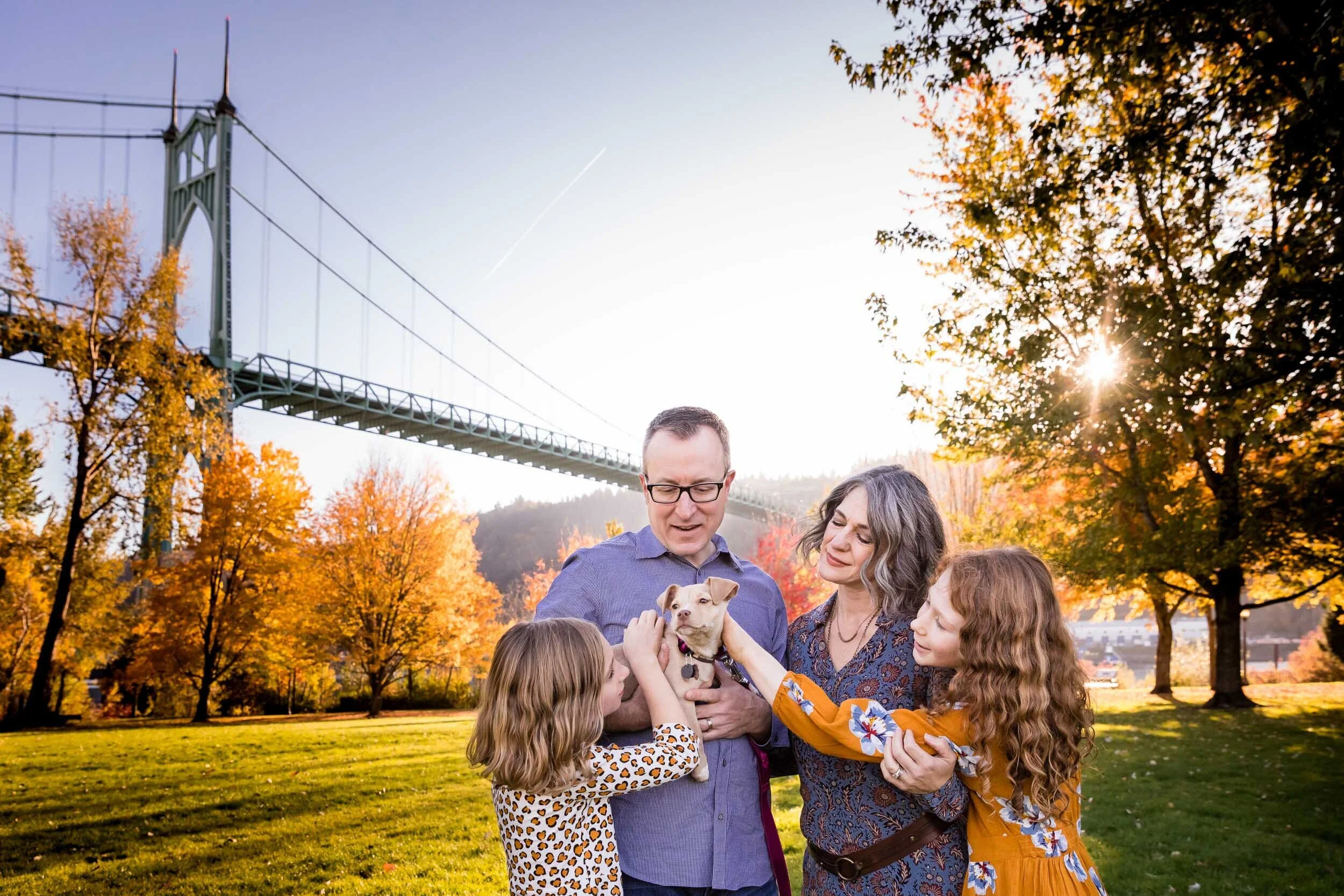 Family Photo With Puppy in Front of Bridge in Fall
