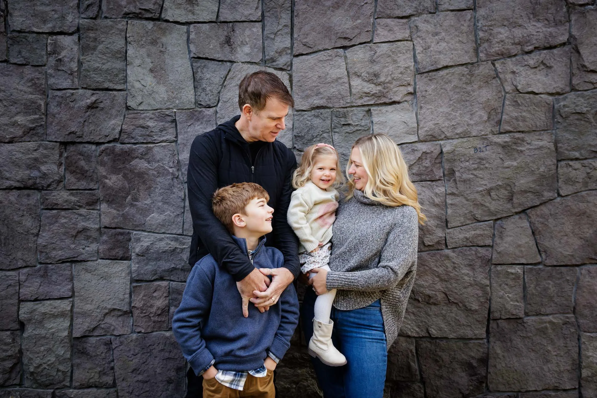 Family of four hanging out and smiling in Portland Park
