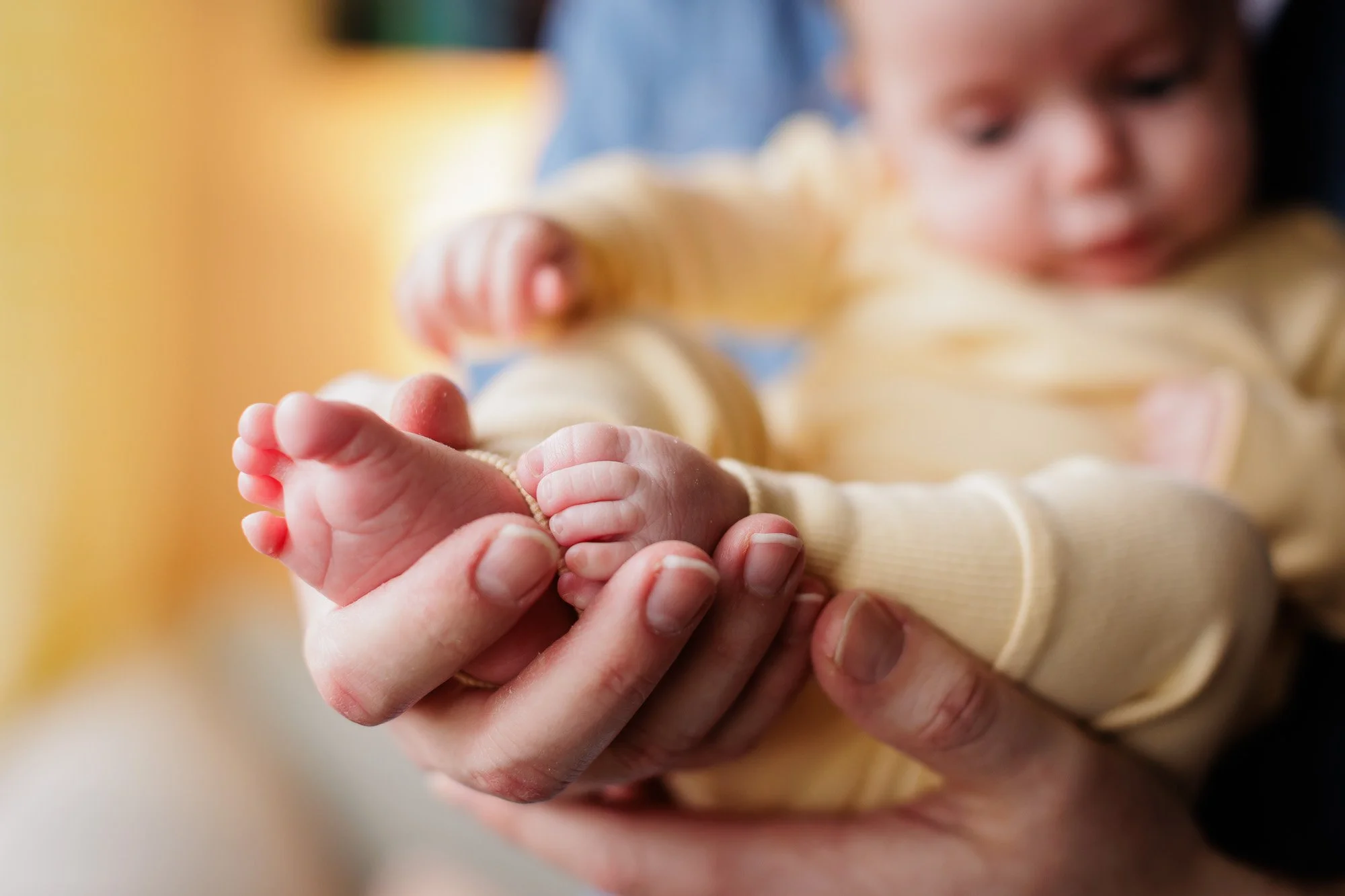 close up photo of baby toes in dads hands