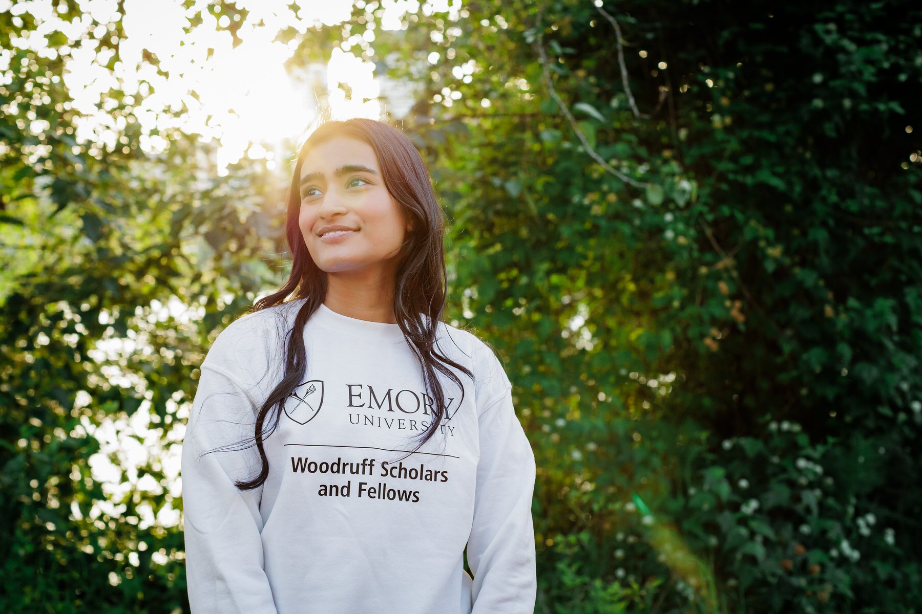 girl wears college sweatshirt for emory university during senior portrait session