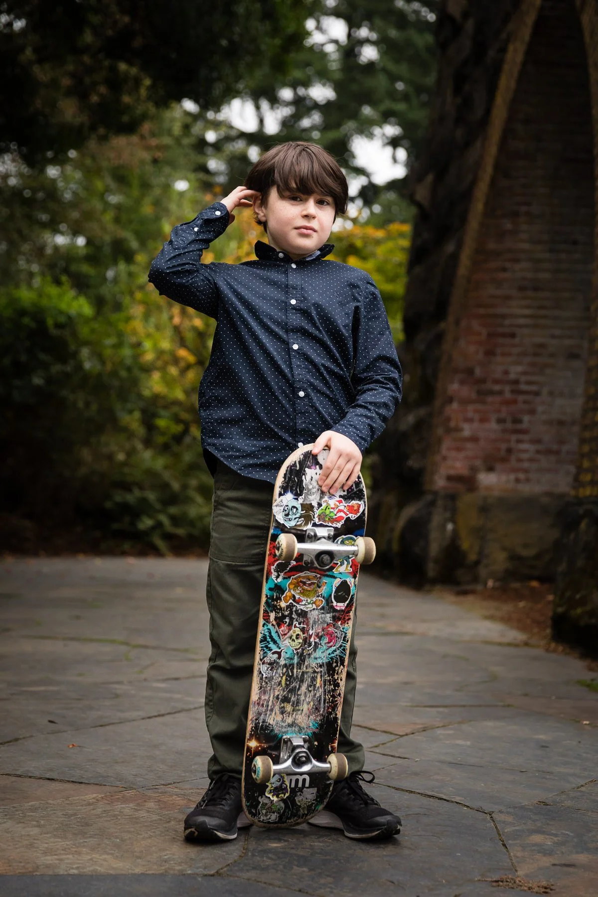 boy holds colorful skateboard at park in lake oswego