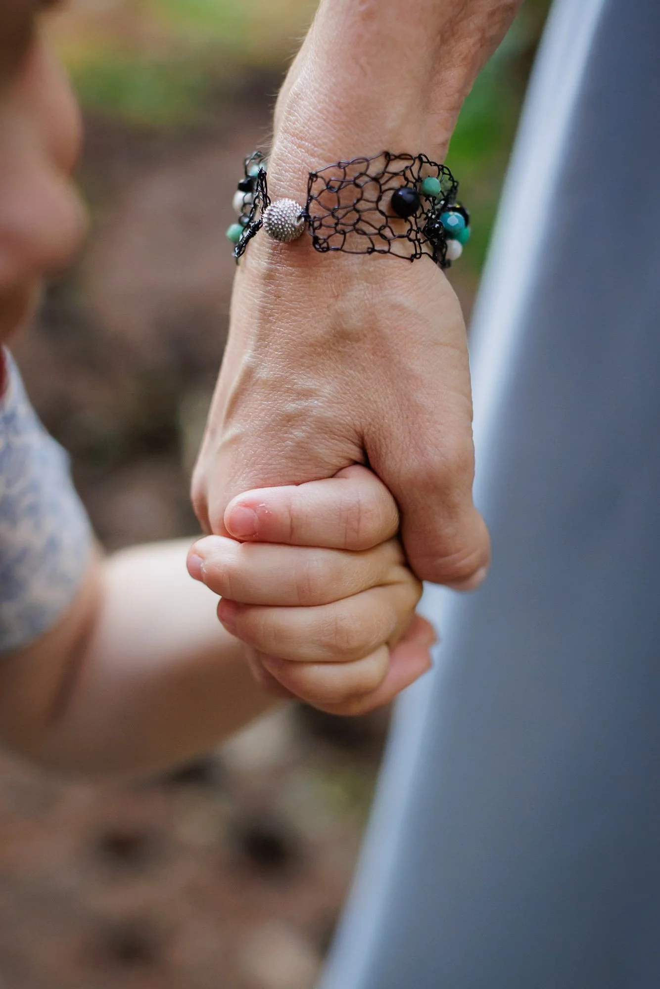 close up detail image of young child holding moms hand
