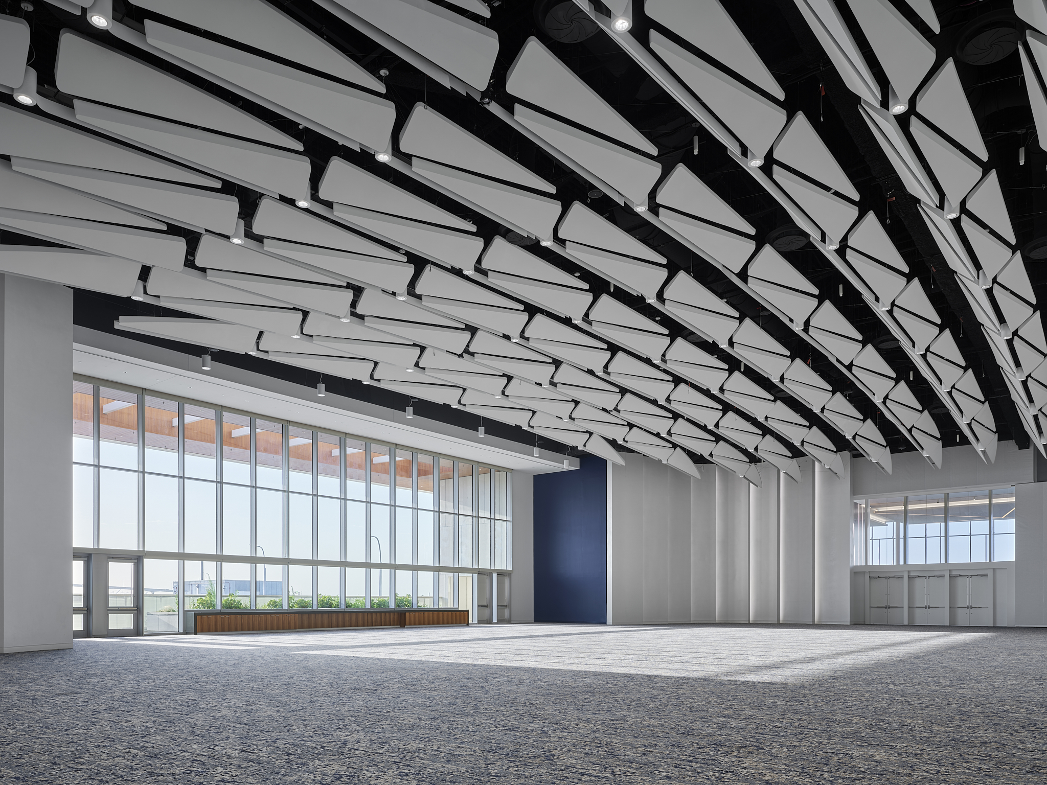 A wide-angle interior architectural photograph of the Savannah Convention Center expansion, showing a larger space and acoustic panels
