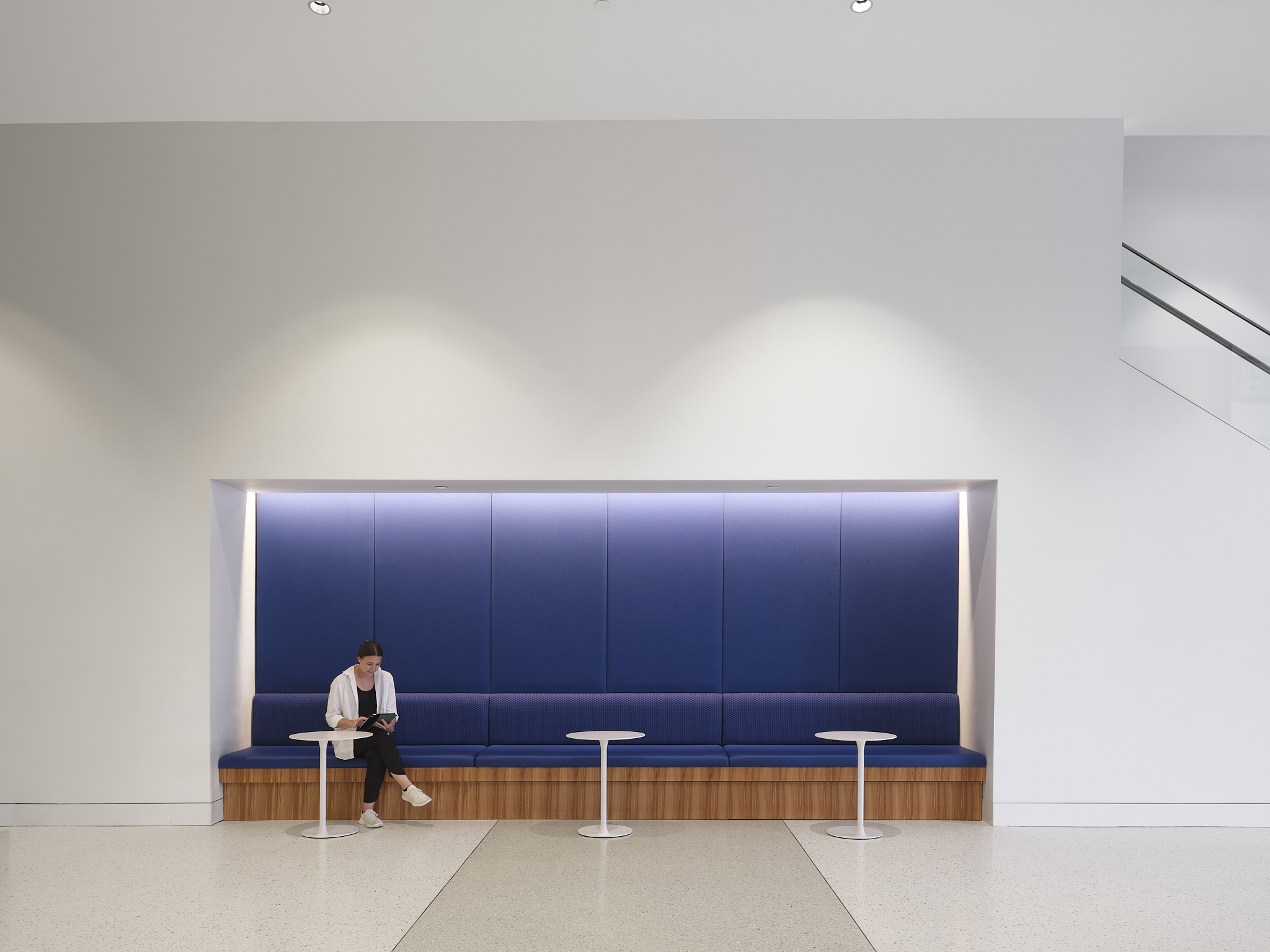 A lifestyle, interior, architectural photograph of the Savannah Convention Center expansion, showing clean lines and lady seated

