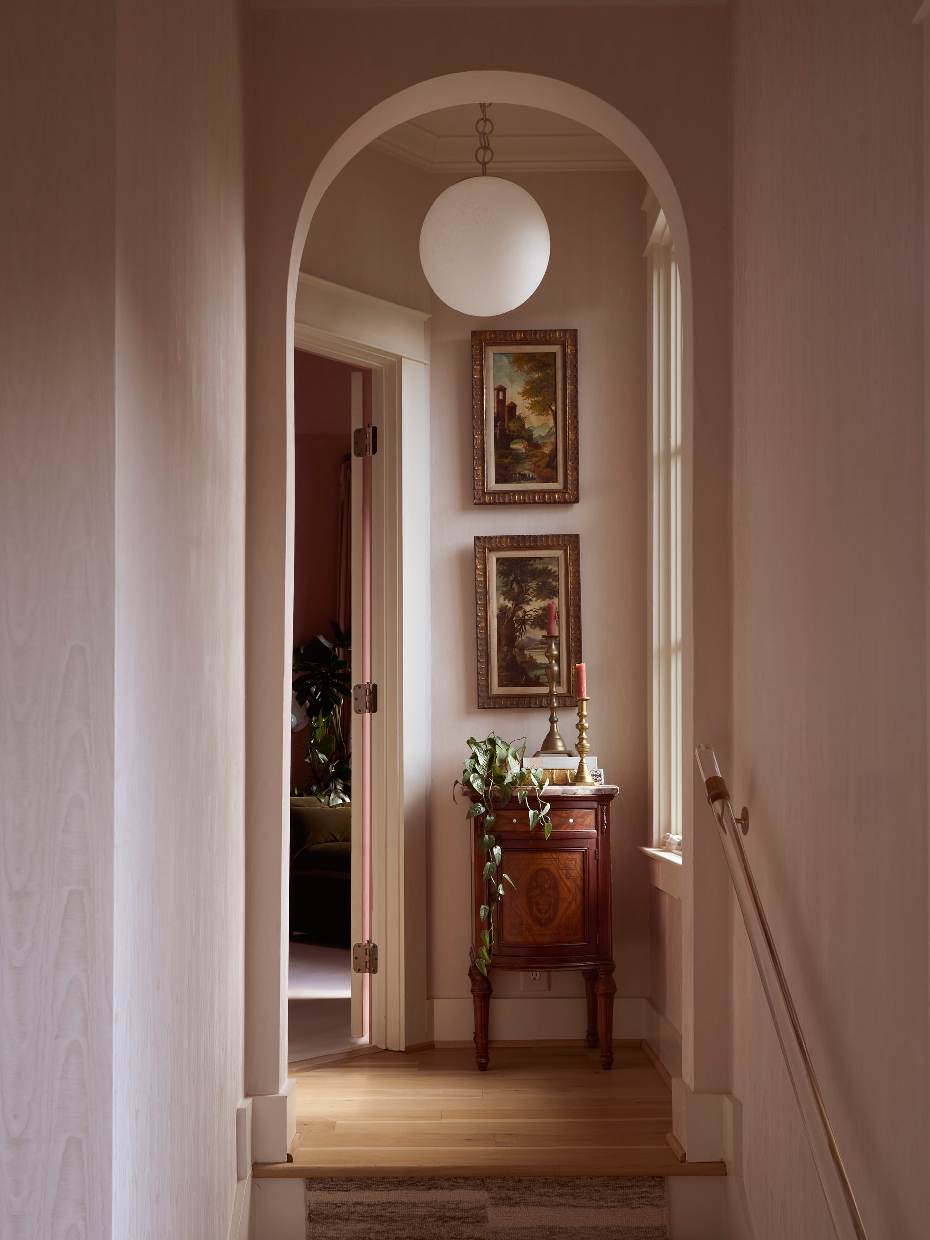 A study in light and shadow within a luxury Nashville private estate. This corridor, designed by Branan White Interior Design, exemplifies the "Old World Modern" trend. The walls are finished in a subtle Roman clay or limewash, providing a soft contr