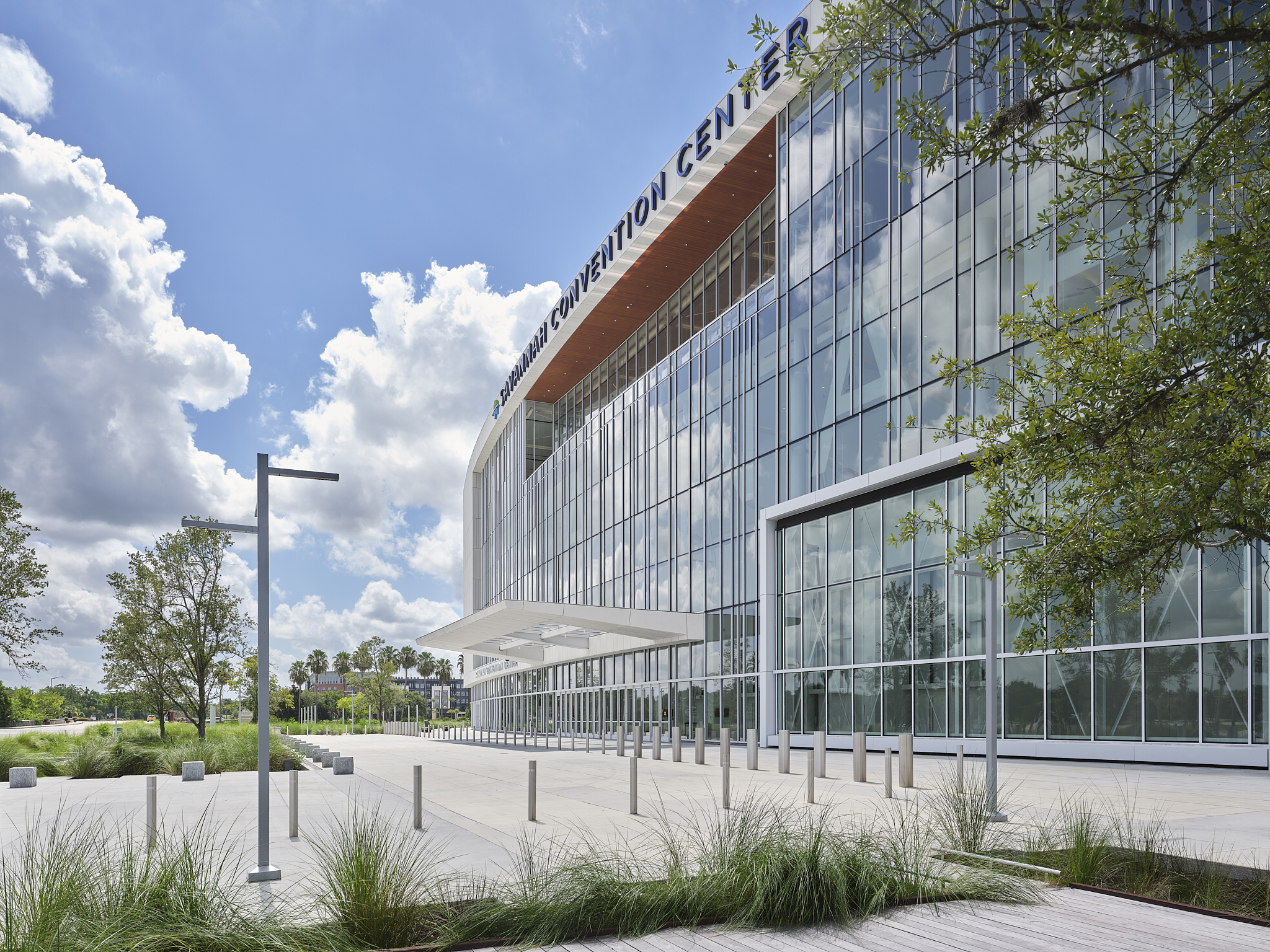 A wide-angle exterior architectural photograph of the Savannah Convention Center expansion, showing the glass facade and hangar
