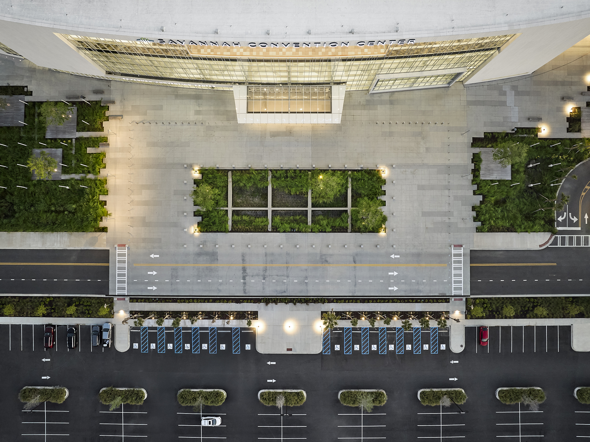 A aerial architectural photograph of the Savannah Convention Center expansion at sunset, showing the entrance and landscape
