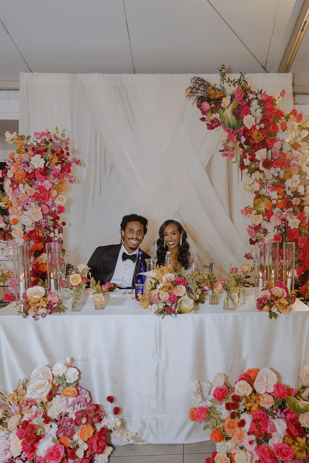 Bold Skyline Events SF wedding with rich deep raspberry, olive green, orange, burgundy, and pink wedding flowers. Featuring striking bridal and bridesmaid bouquets, ceremony florals, colorful reception centerpieces, lush aisle arrangements, and premi